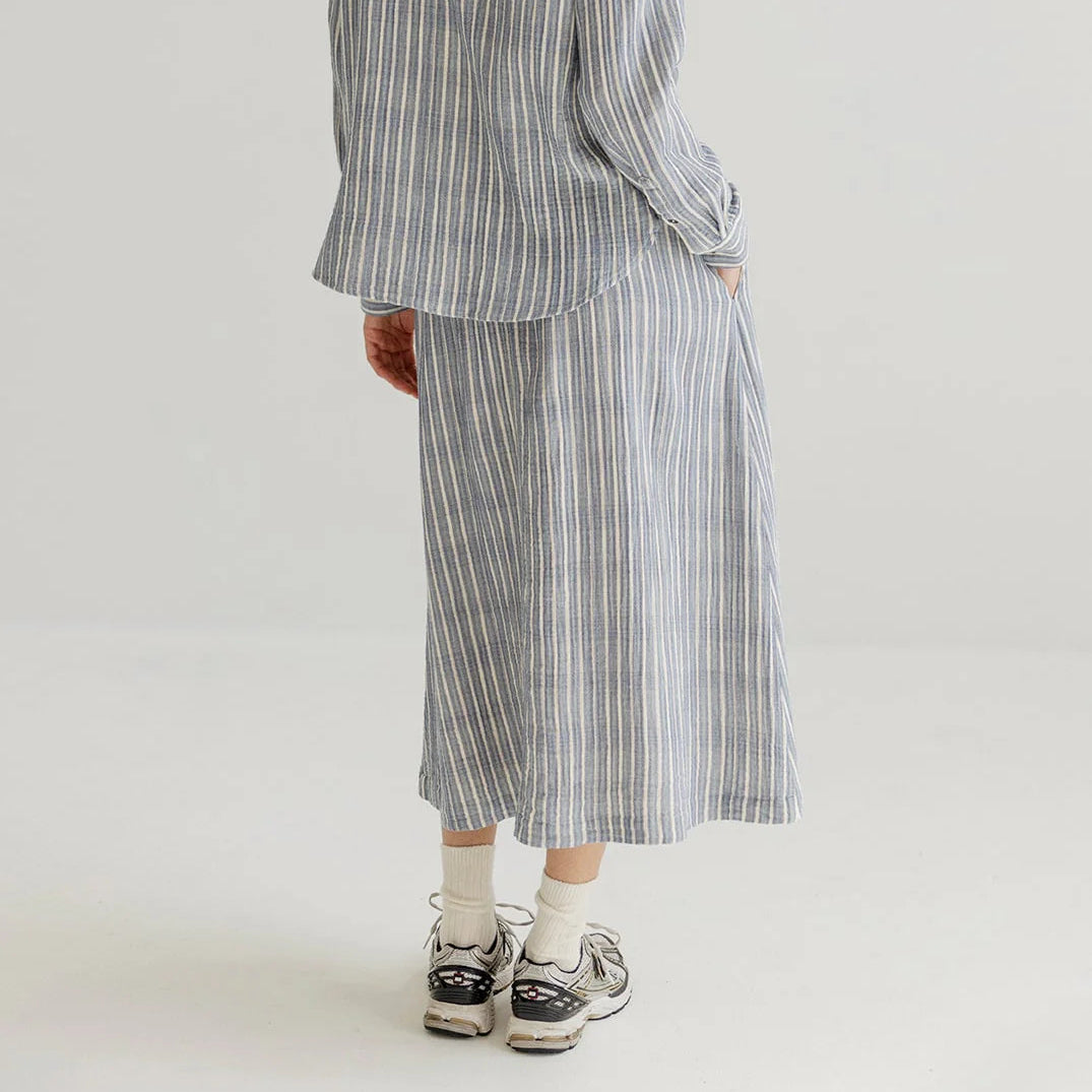 Person wearing a striped outfit on a plain background