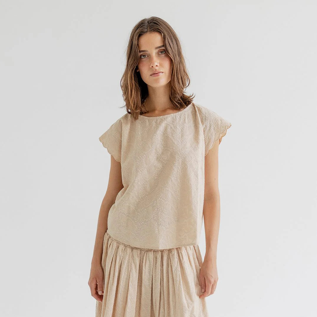 women wearing a cream embroidered blouse