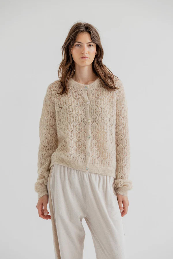Woman wearing a beige knitted sweater and pants on a white background