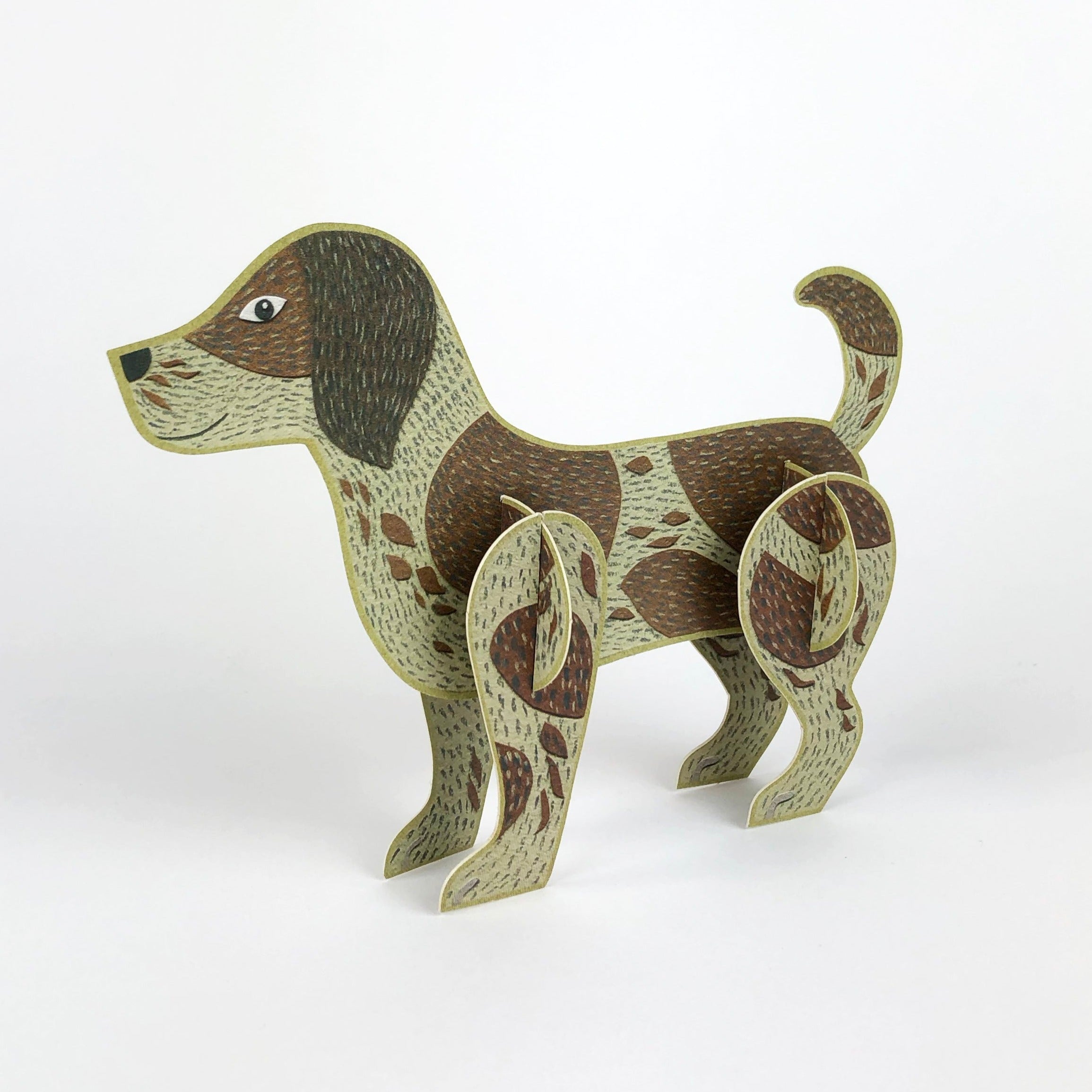Brown and tan paper dog model, standing, illustrated with spots and textured fur.  The dog has floppy ears and a curled tail.