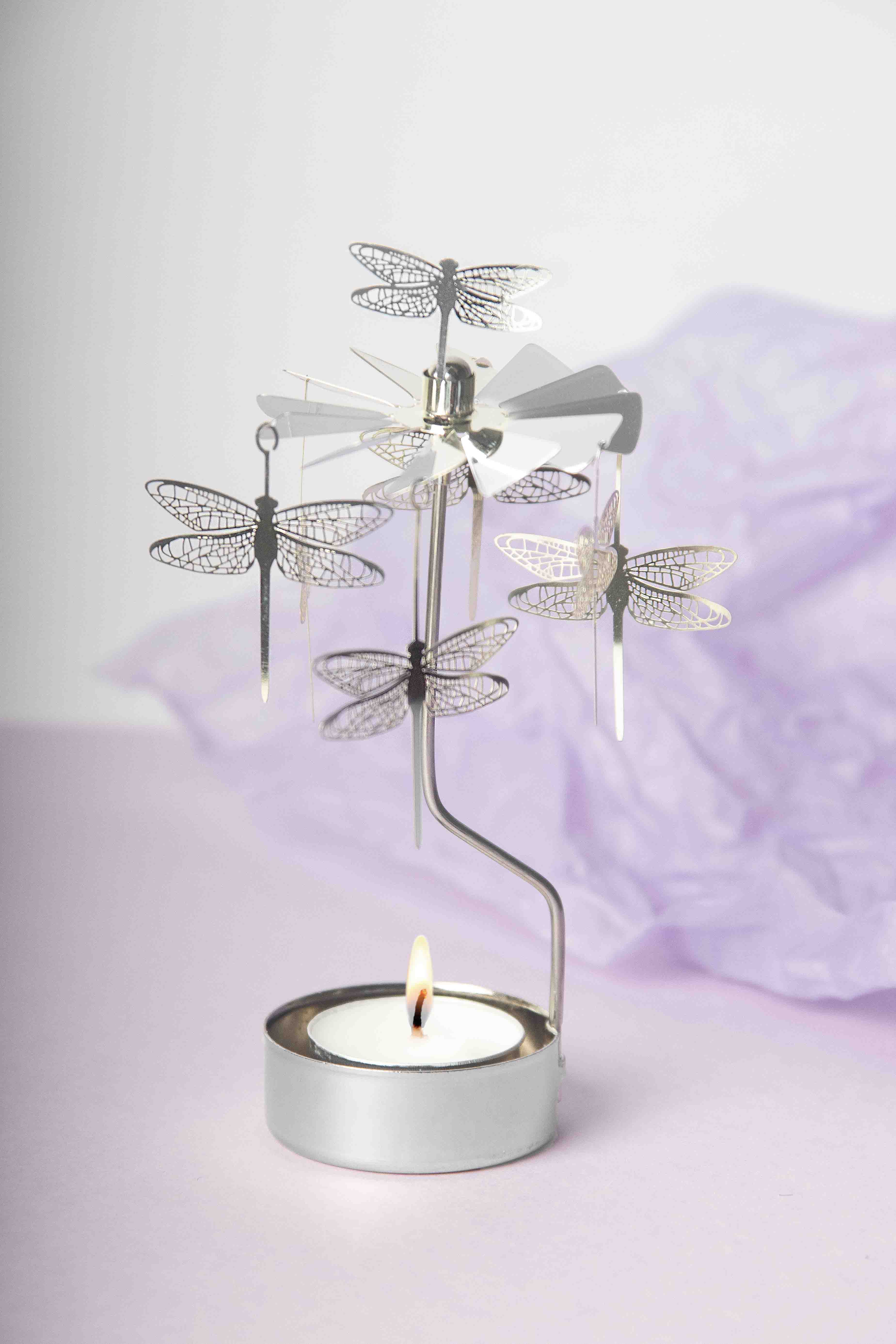 Decorative candle holder with dragonfly design on a light purple background