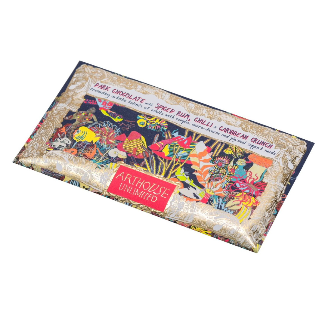 Dark chocolate bar with spiced rum, chili, and Caribbean crunch. Features colorful artwork of fish and coral on the wrapper.