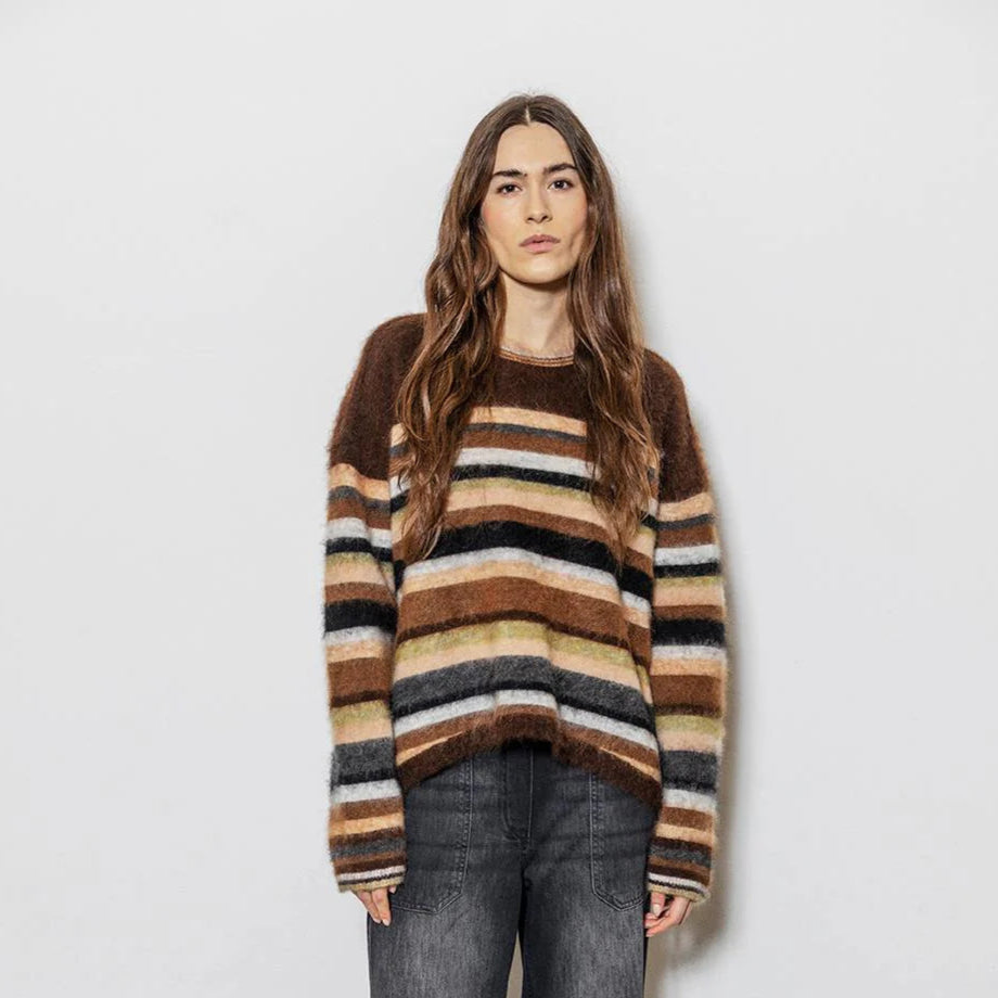 Woman wearing a striped sweater with a plain background