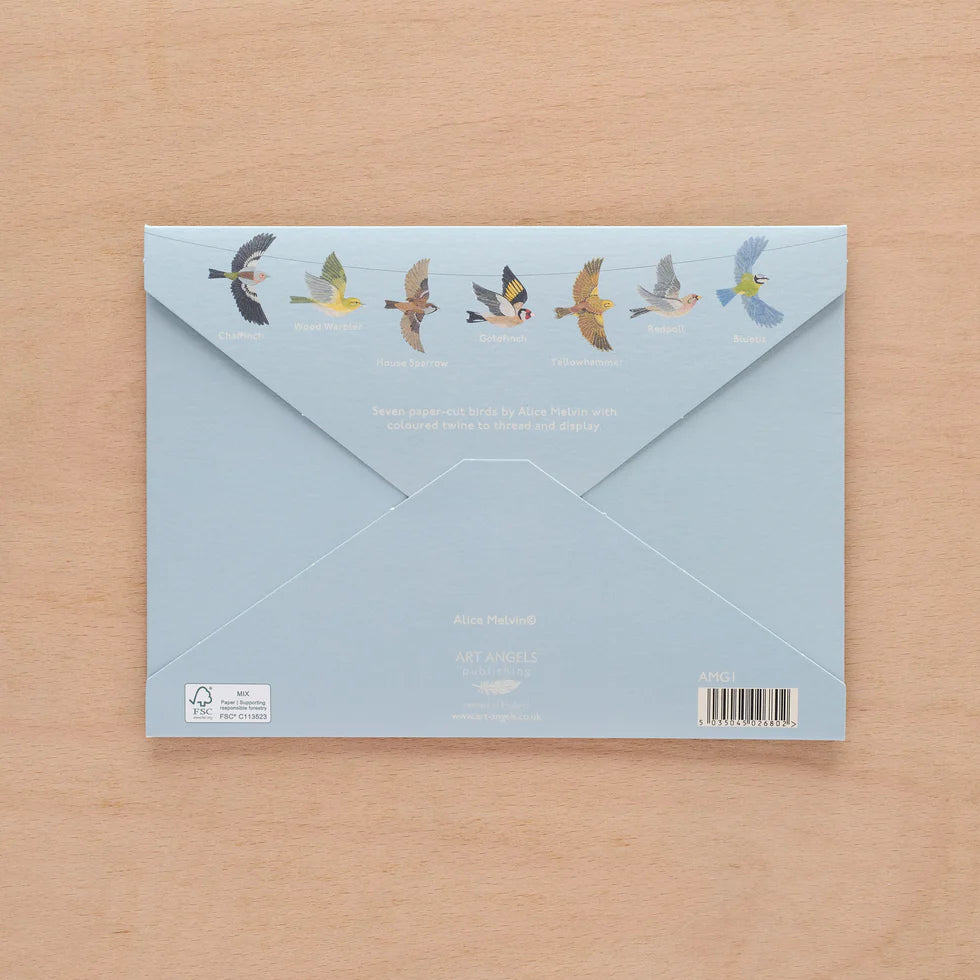 Blue envelope with bird illustrations on a wooden surface