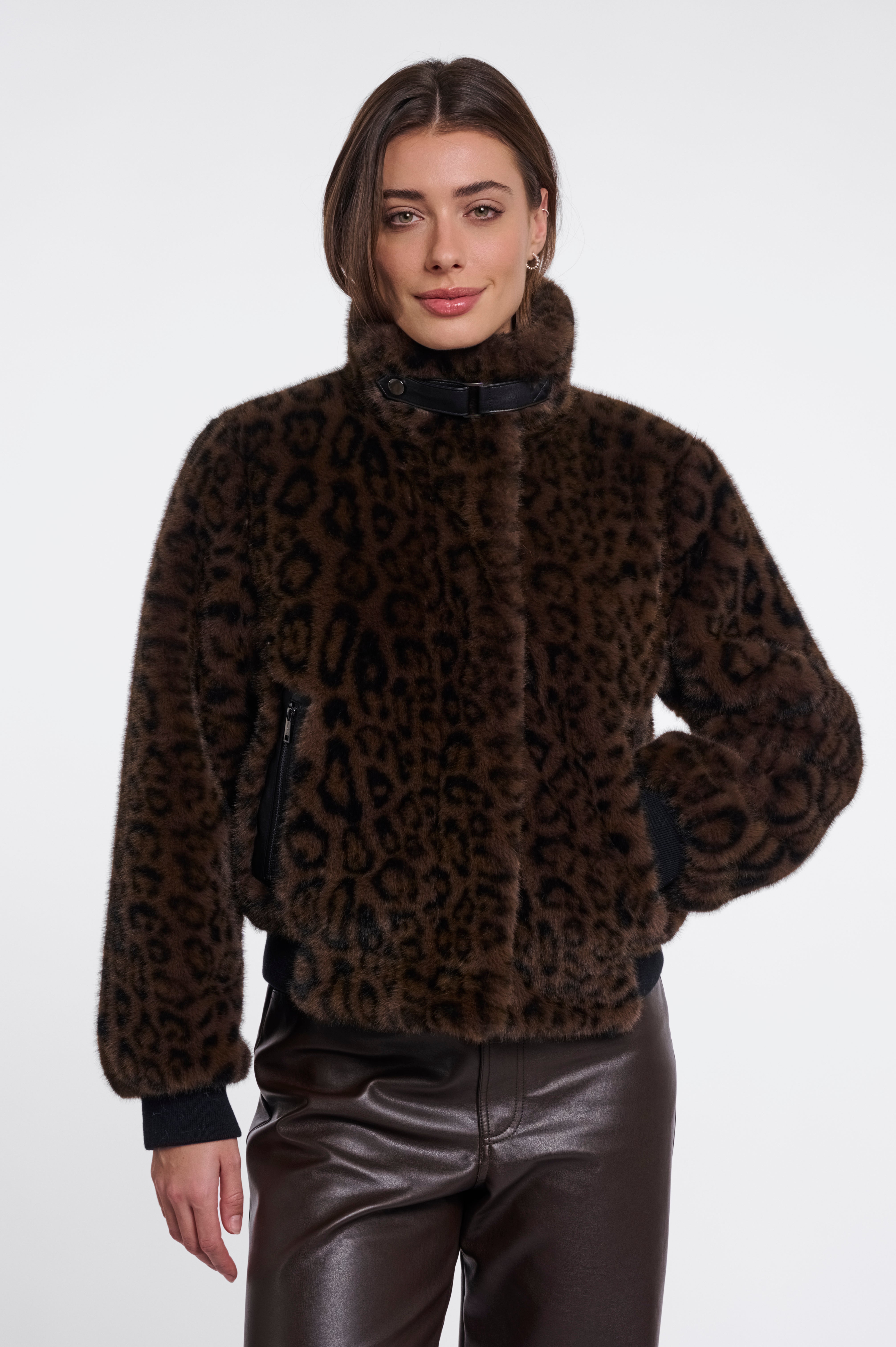 Woman wearing a brown leopard print sweater and black pants on a white background