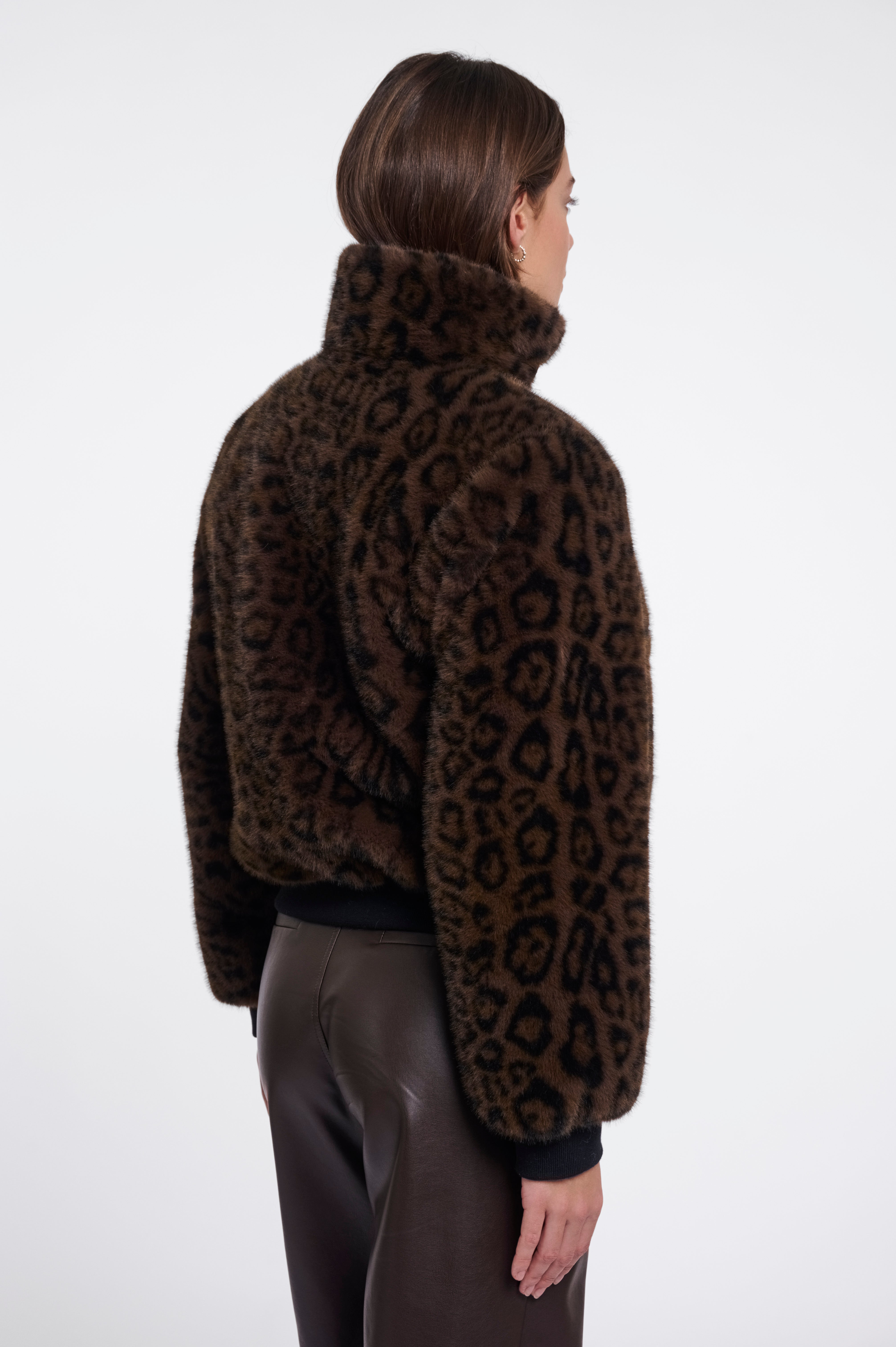 Person wearing a leopard print jacket on a white background