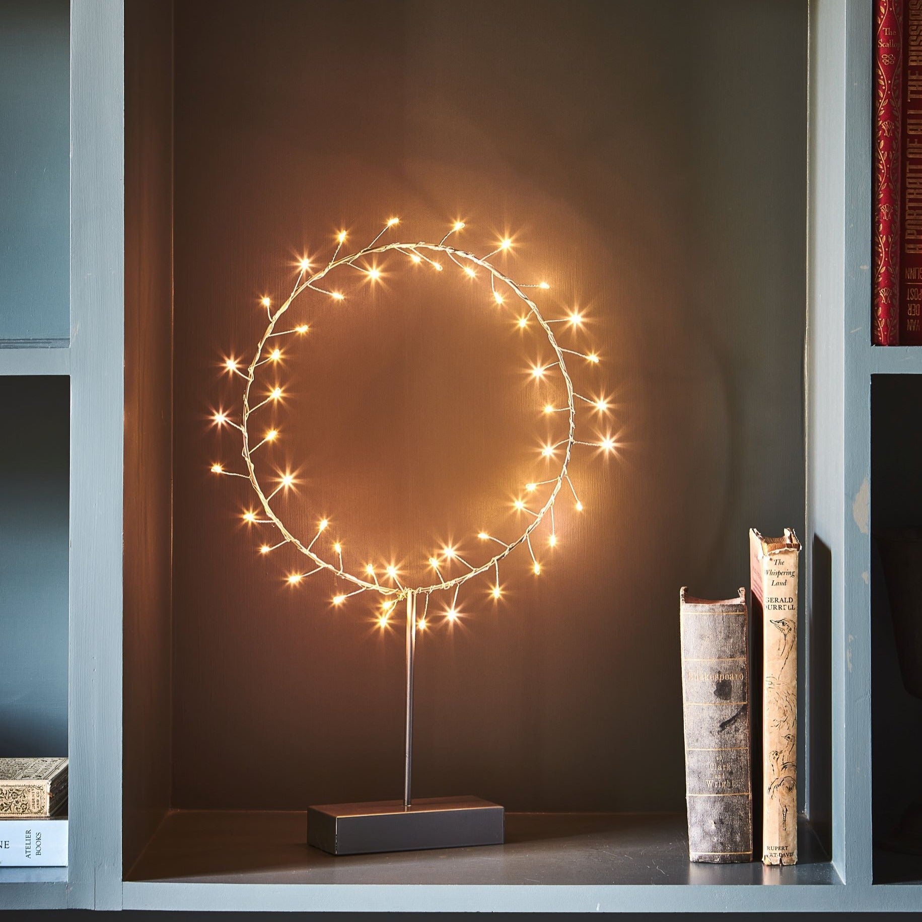 Circular LED light fixture with warm-toned lights on a dark gray base.