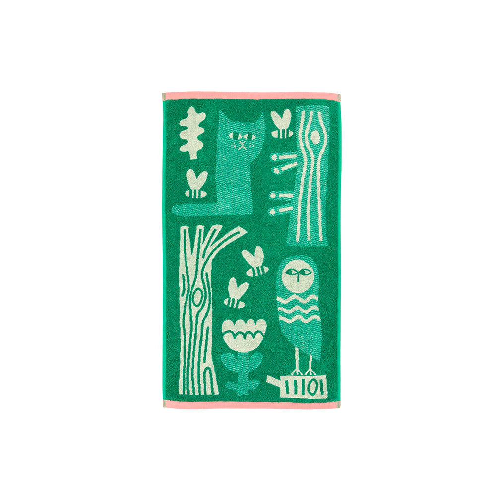 Green towel with white animal and plant patterns, featuring a pink border; designed by Donna Wilson.