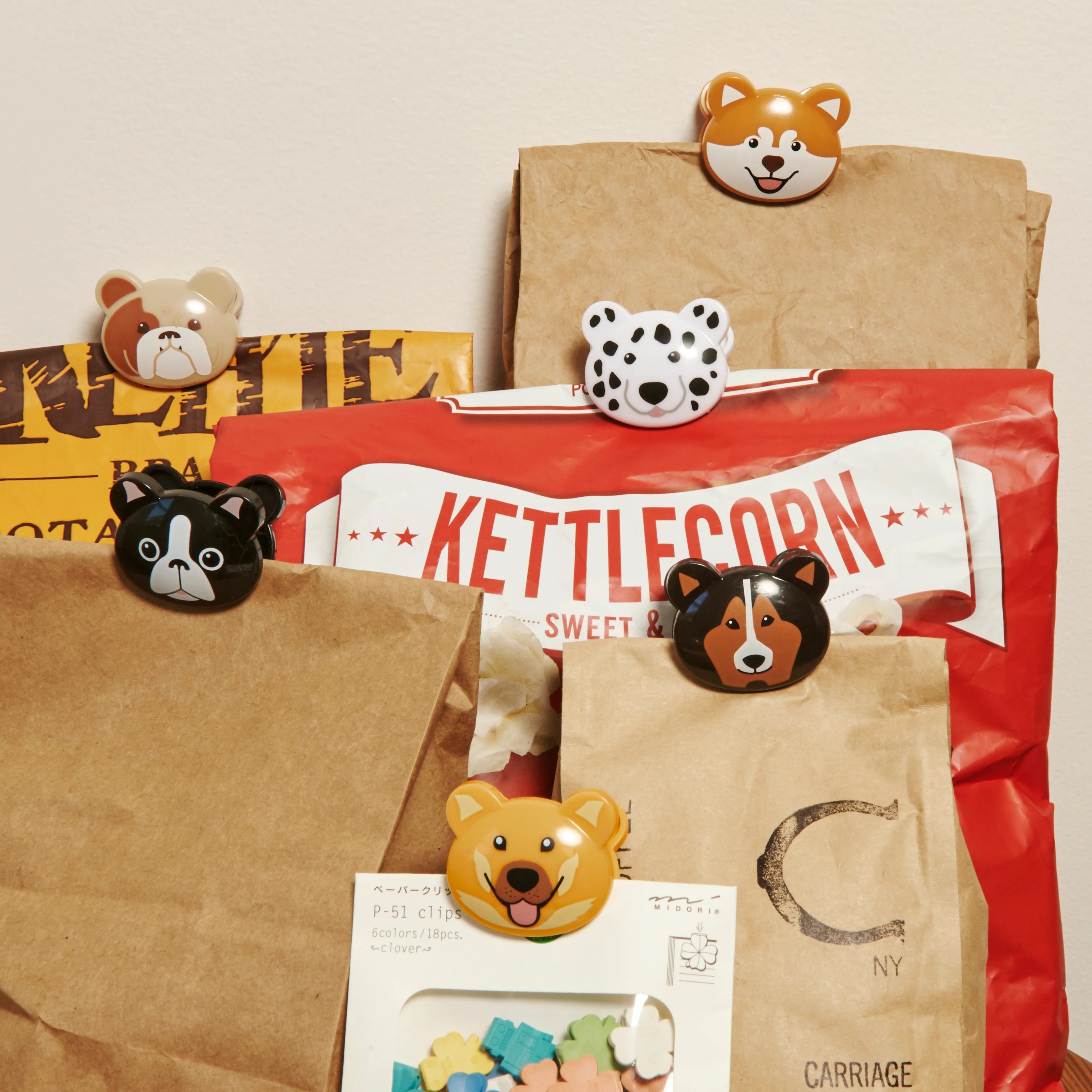 Assortment of adorable dog-shaped bag clips in various colors and breeds, securing paper bags.
