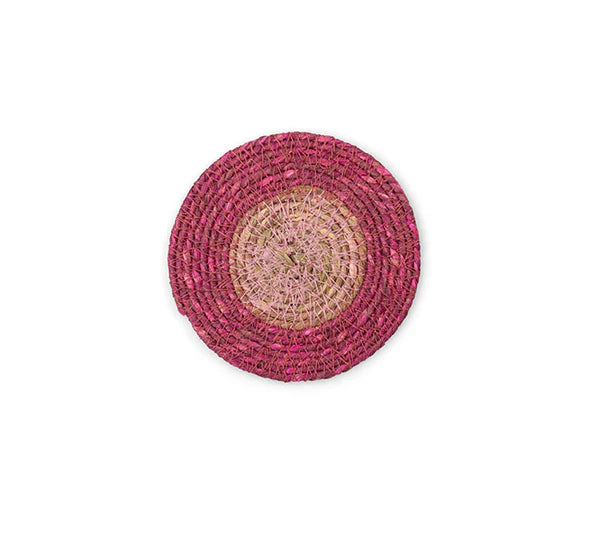 Round pink and beige woven mat on a white background