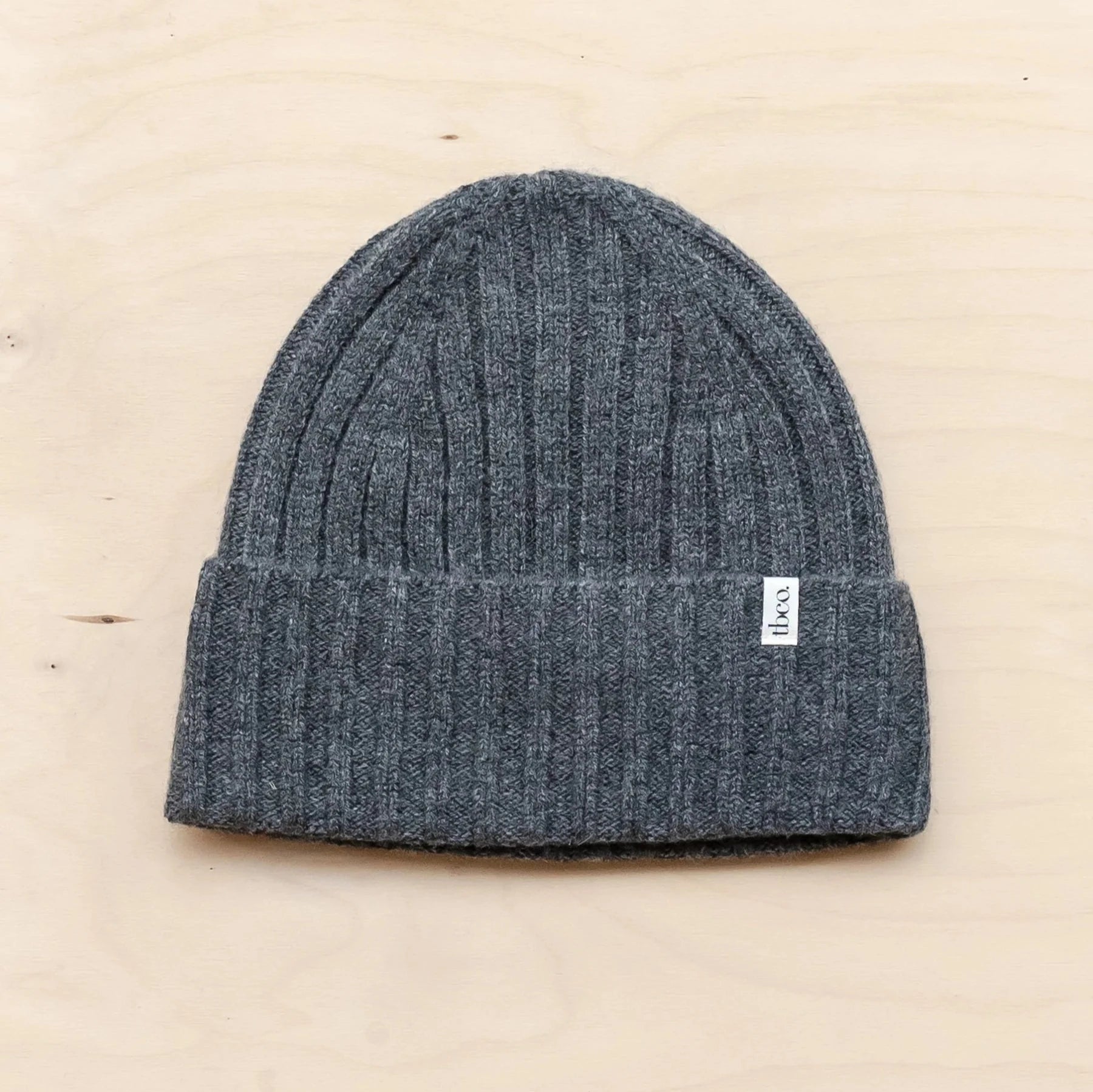 Dark gray ribbed knit beanie with a small white label.