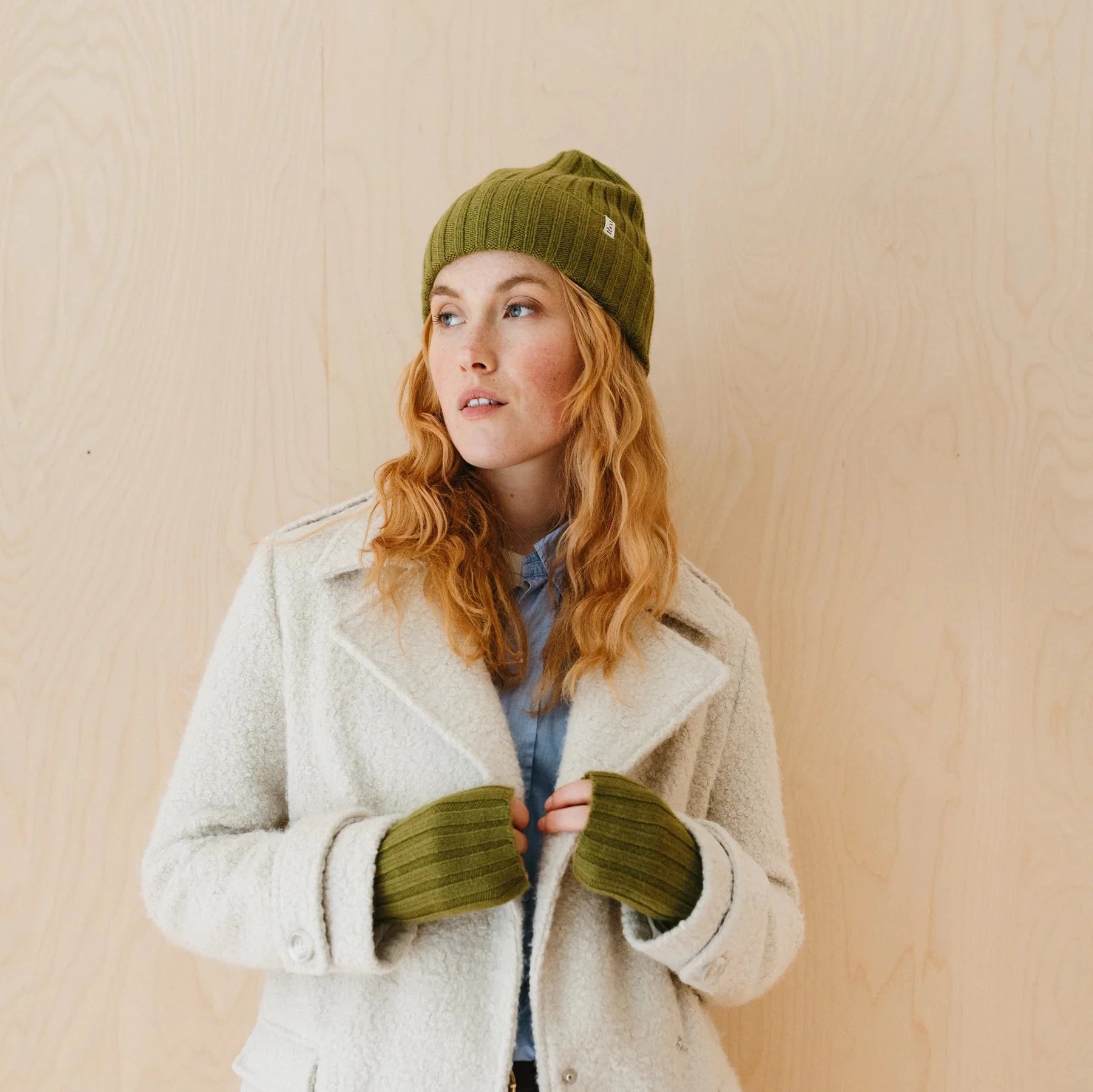 Olive green ribbed knit beanie and matching fingerless gloves.