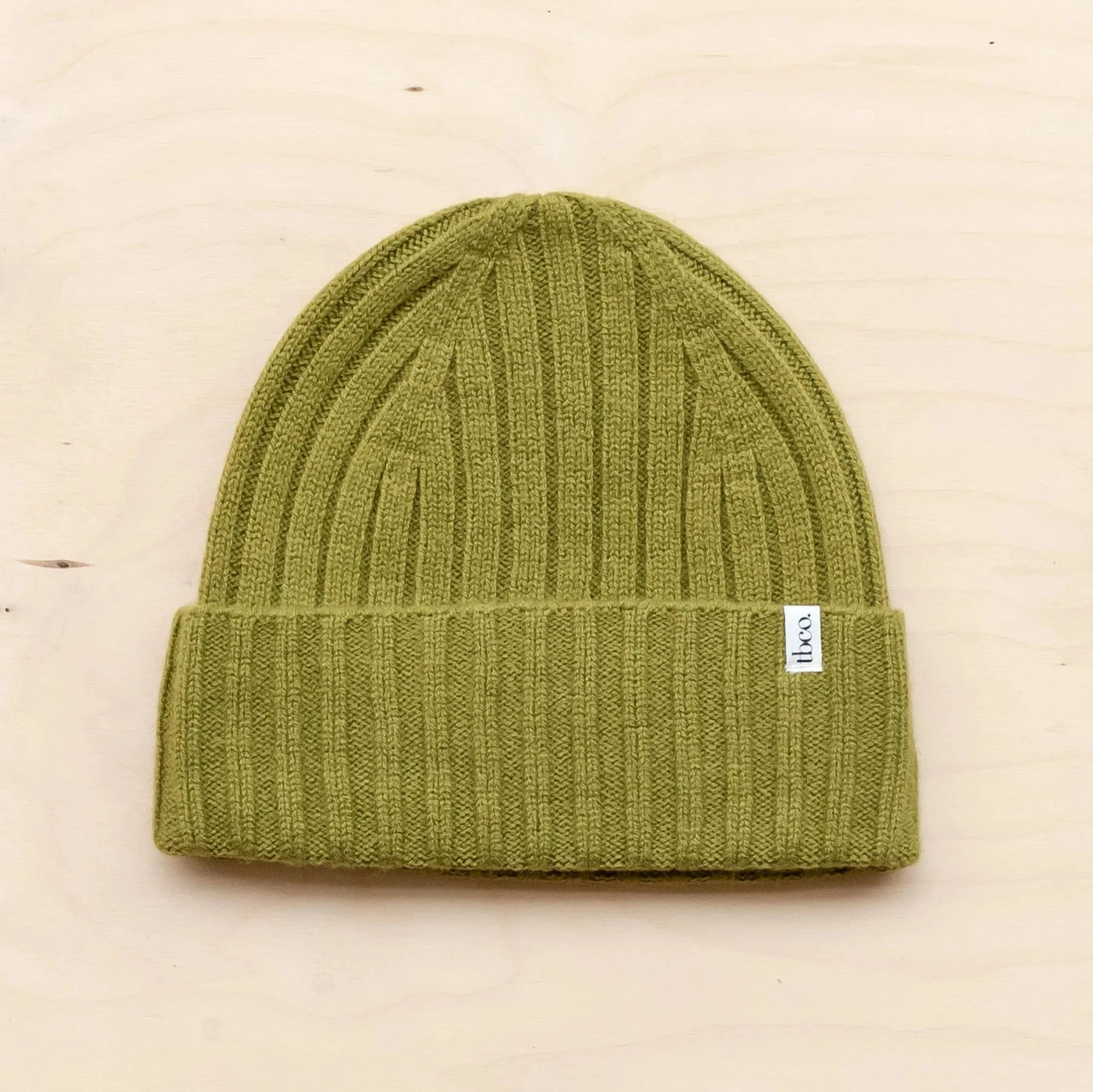 Olive green ribbed knit beanie with a small brand label.