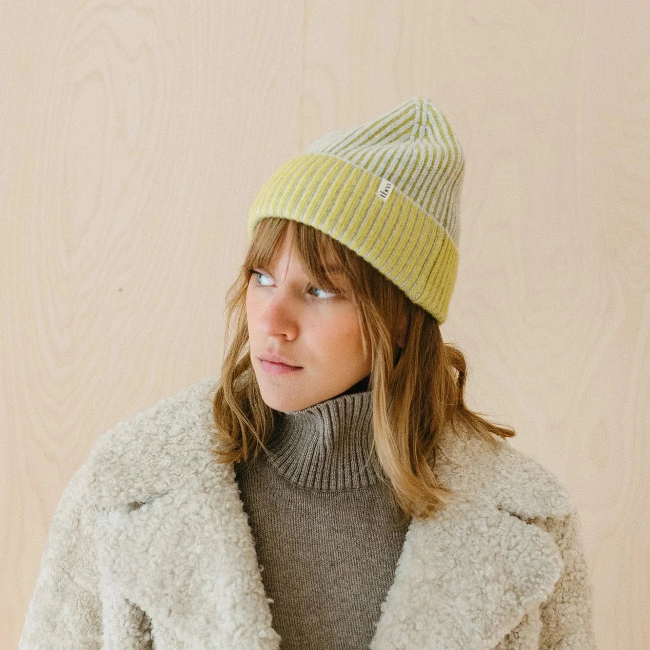 Striped knit beanie in pale yellow and grey.