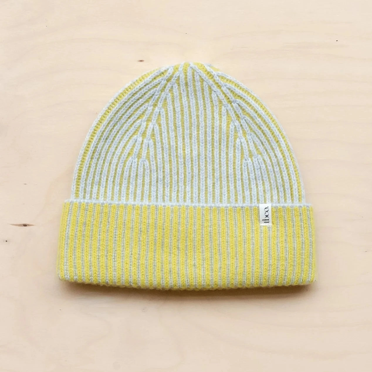 Ribbed knit beanie in pale yellow and grey, featuring a two-tone design.