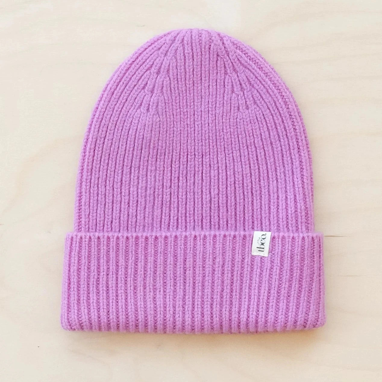 Lilac ribbed knit beanie with small white label.
