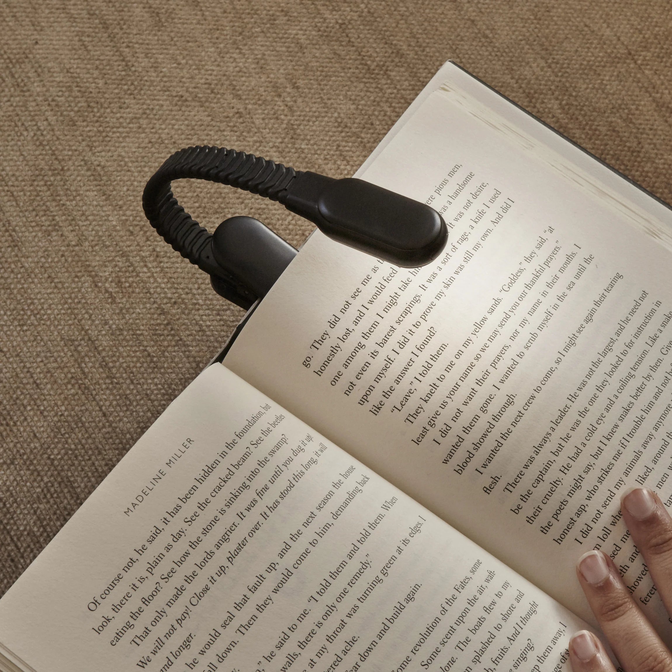 Black book clip-on LED reading light.  Flexible gooseneck design.  Attached to open book.
