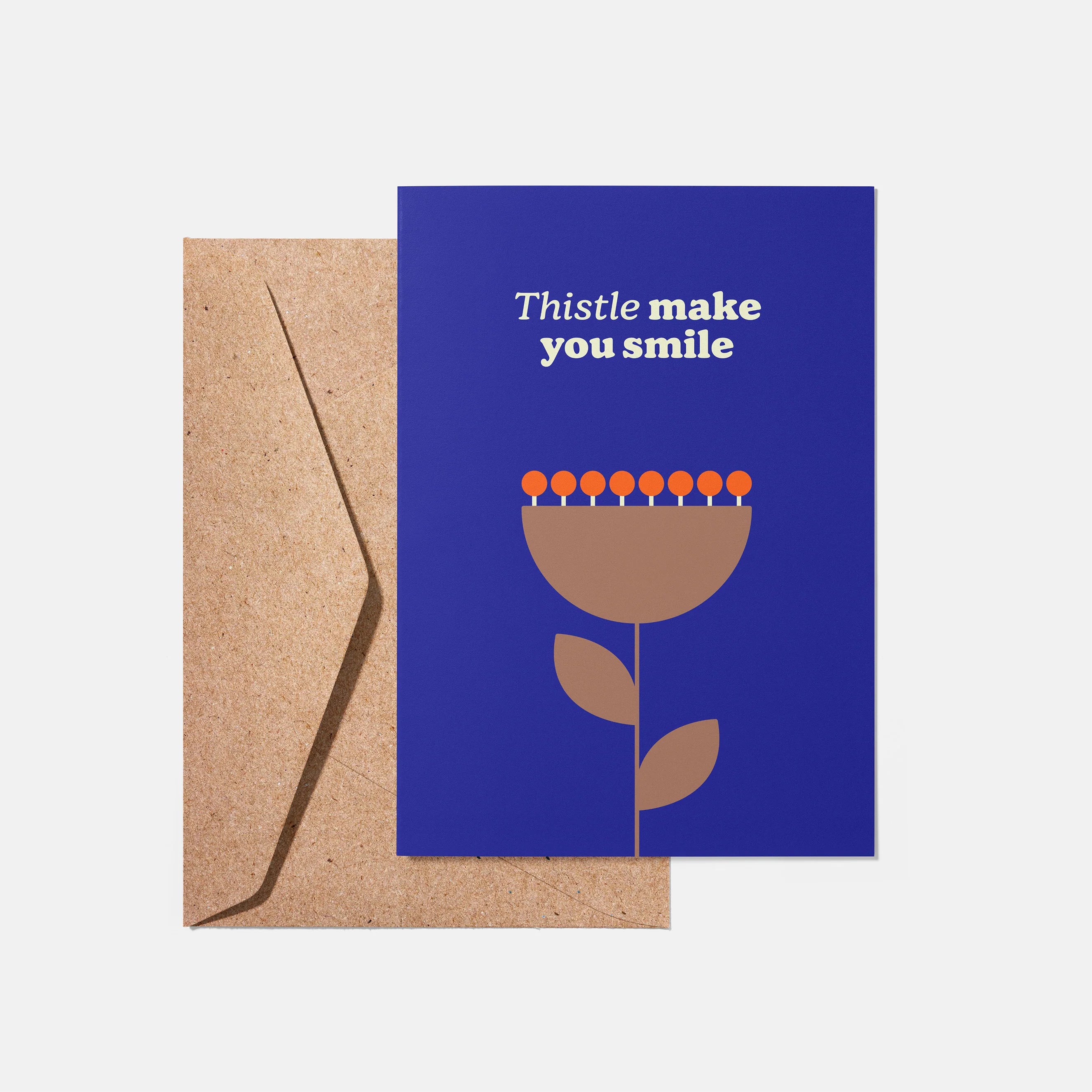 Greeting card with a blue background and brown flower illustration, accompanied by a brown envelope.