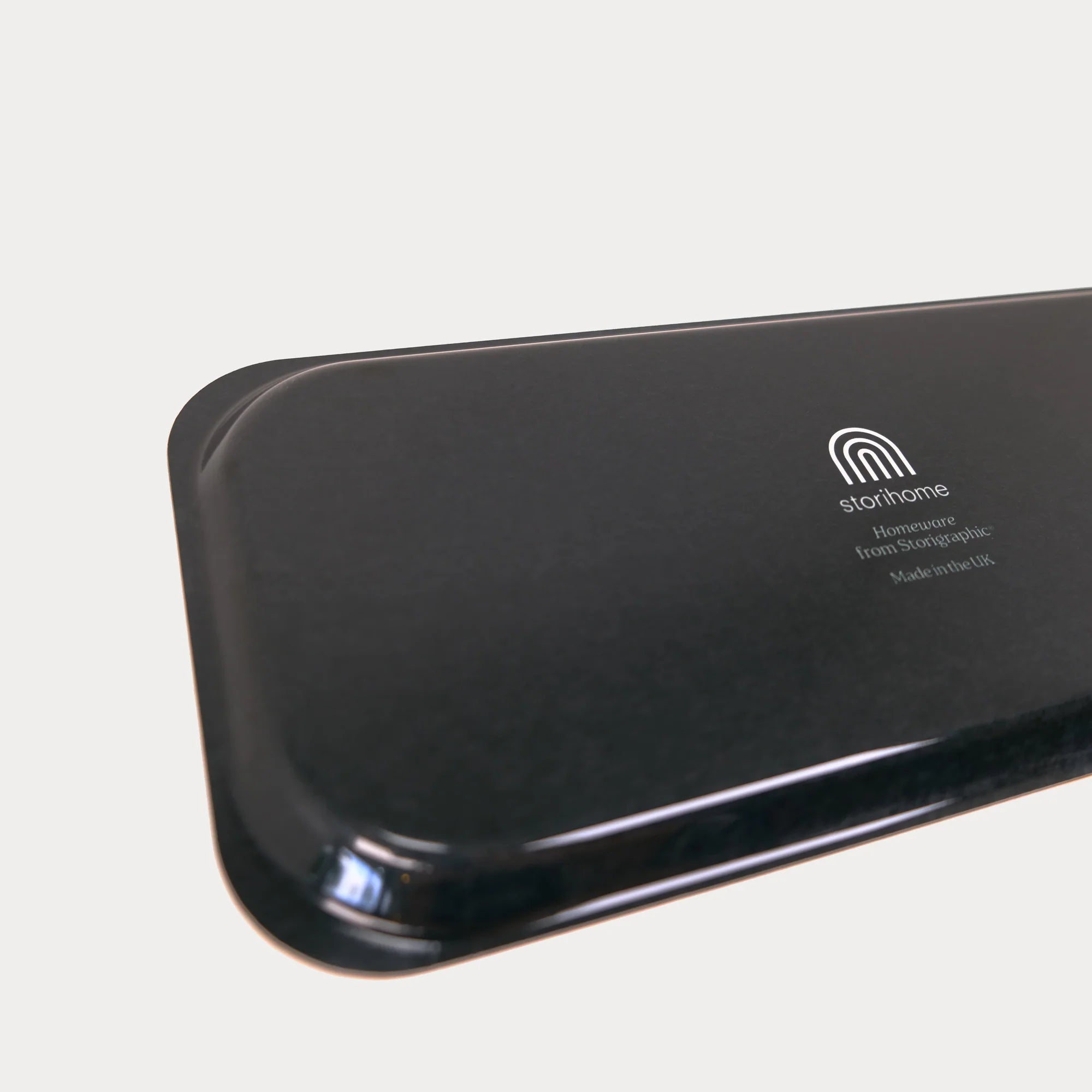 Black electronic device with 'storhome' logo on a light gray background