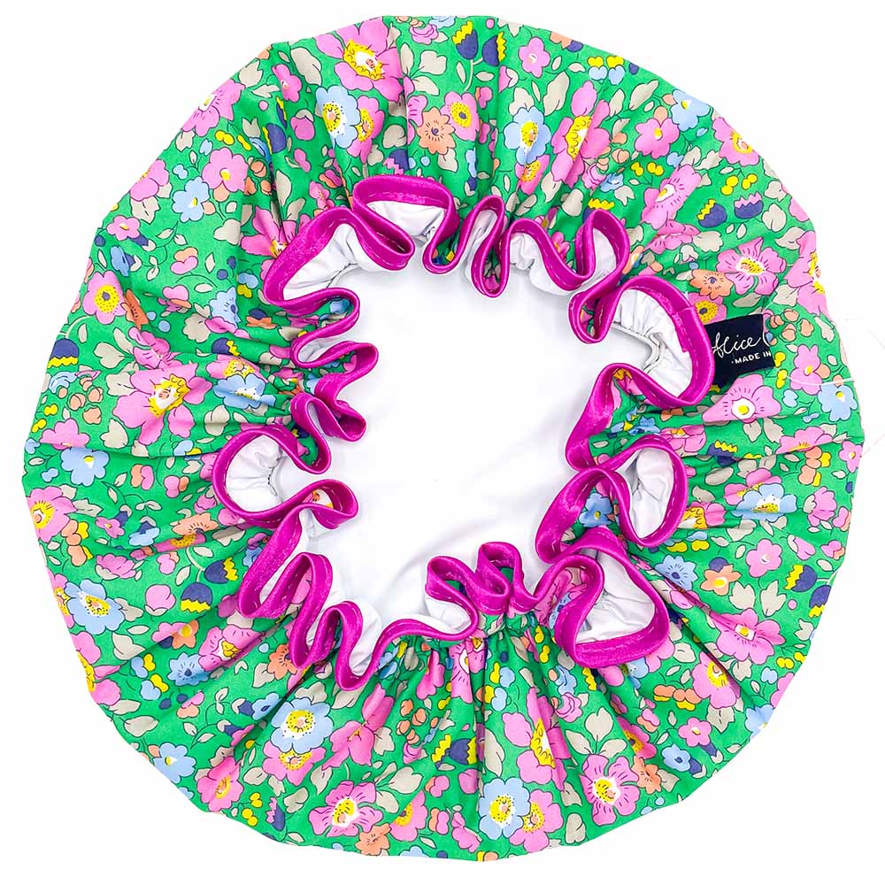 Green floral shower cap with pink ruffled trim and white interior lining.