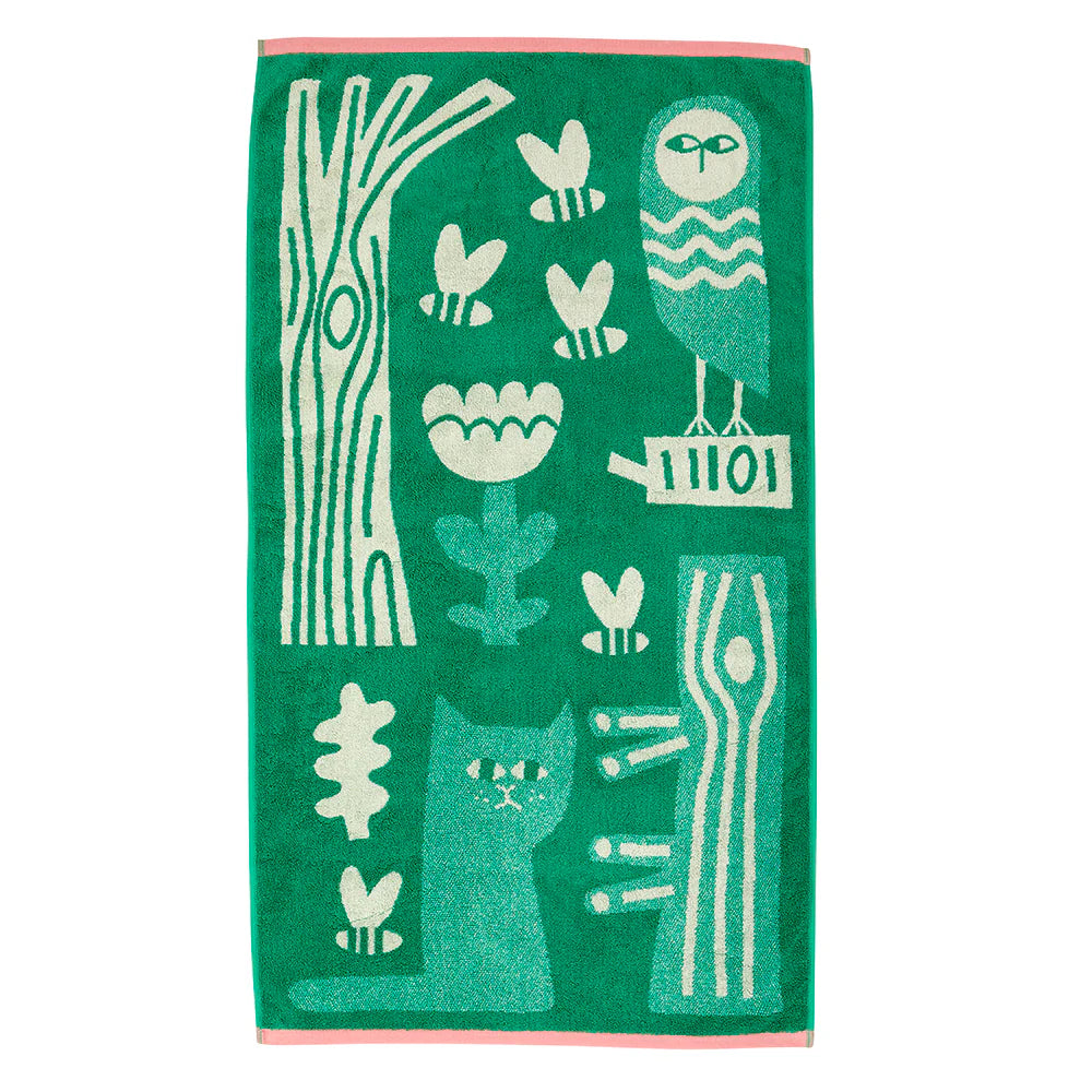 Green towel by Donna Wilson featuring white woodland motifs and a pink border.