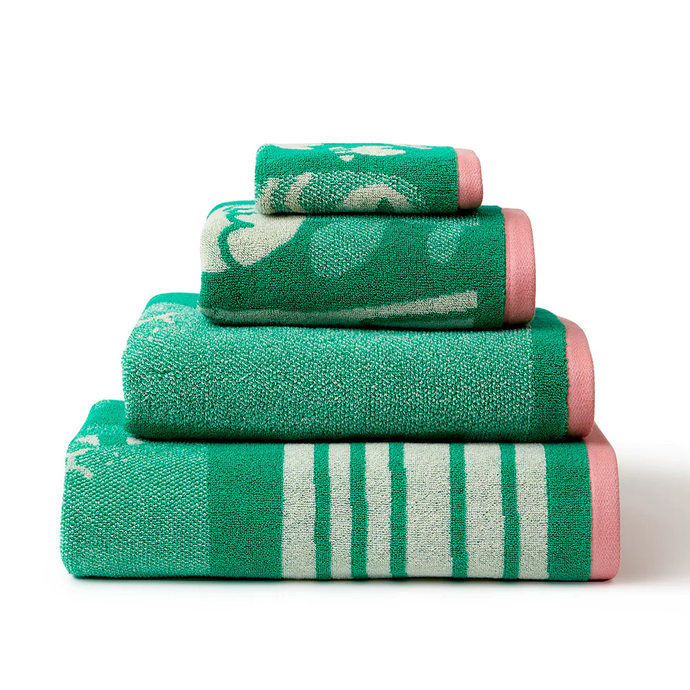 Four stacked towels in green and pale green with pink borders, by Donna Wilson.