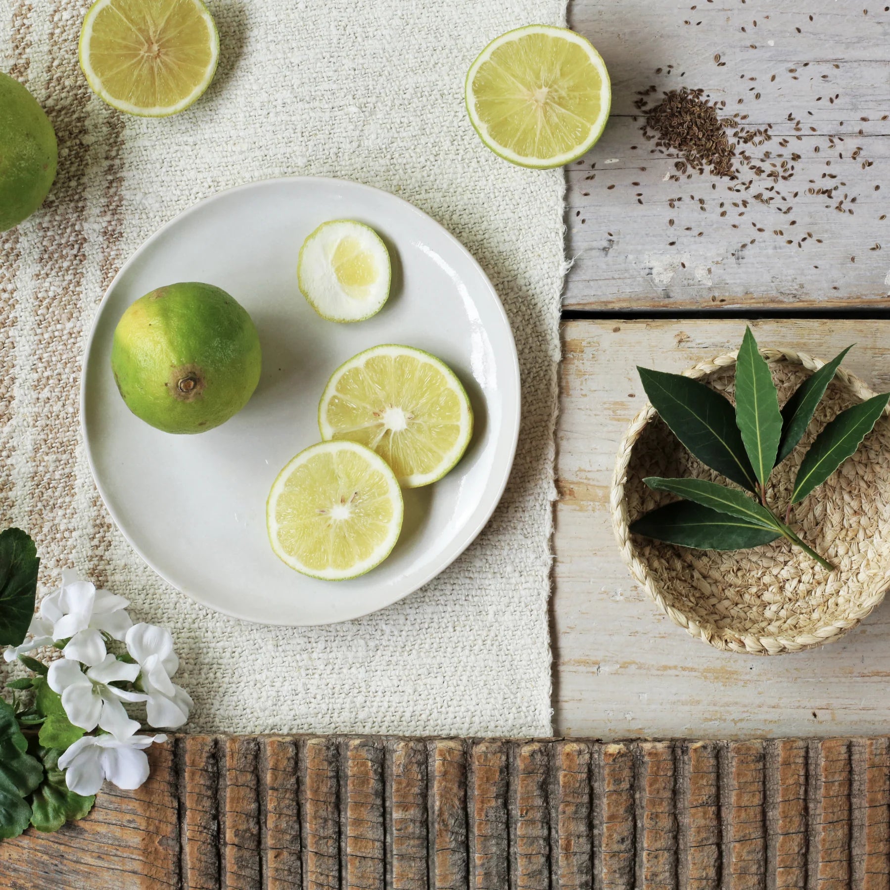 Plate of sliced and whole limes; some lime wedges and a whole lime are on a white plate.