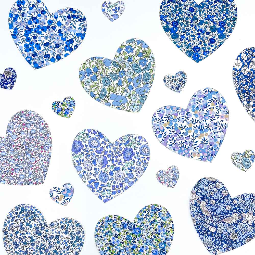 Collection of blue and white floral Liberty print hearts of varying sizes.