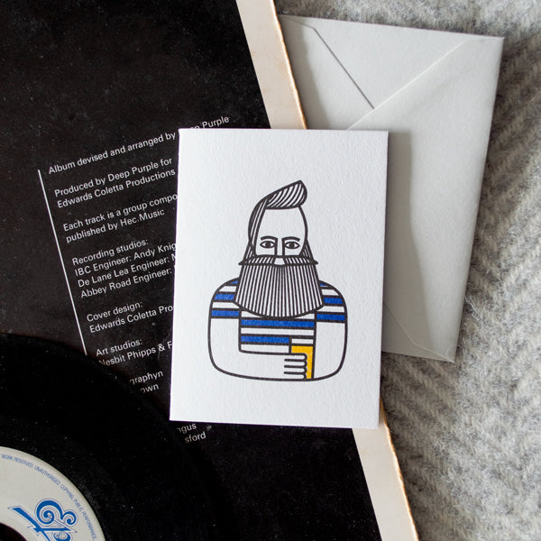 Greeting card featuring a stylized illustration of a bearded man in a striped shirt, holding a drink.