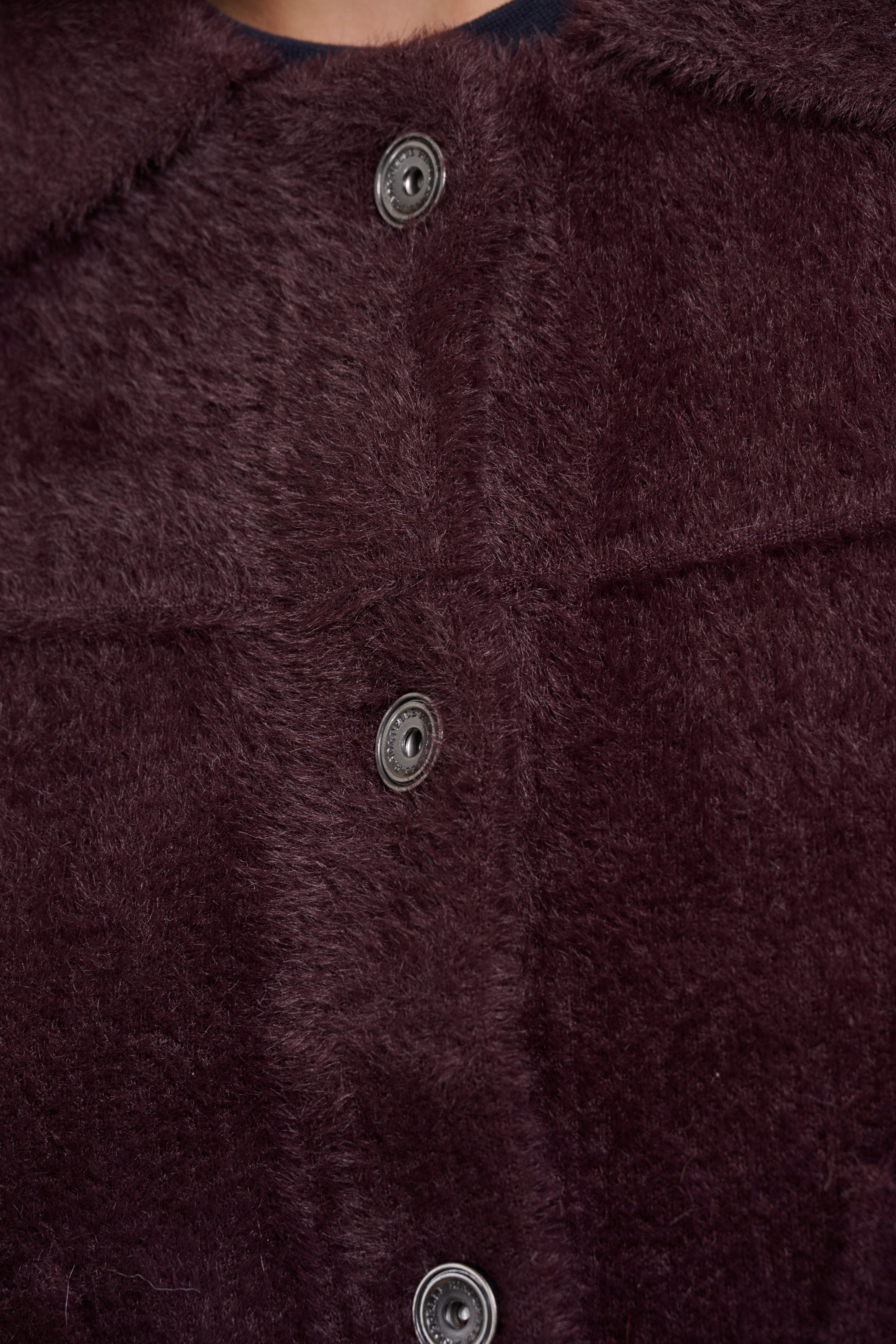 Close-up of a dark brown textured fabric with buttons