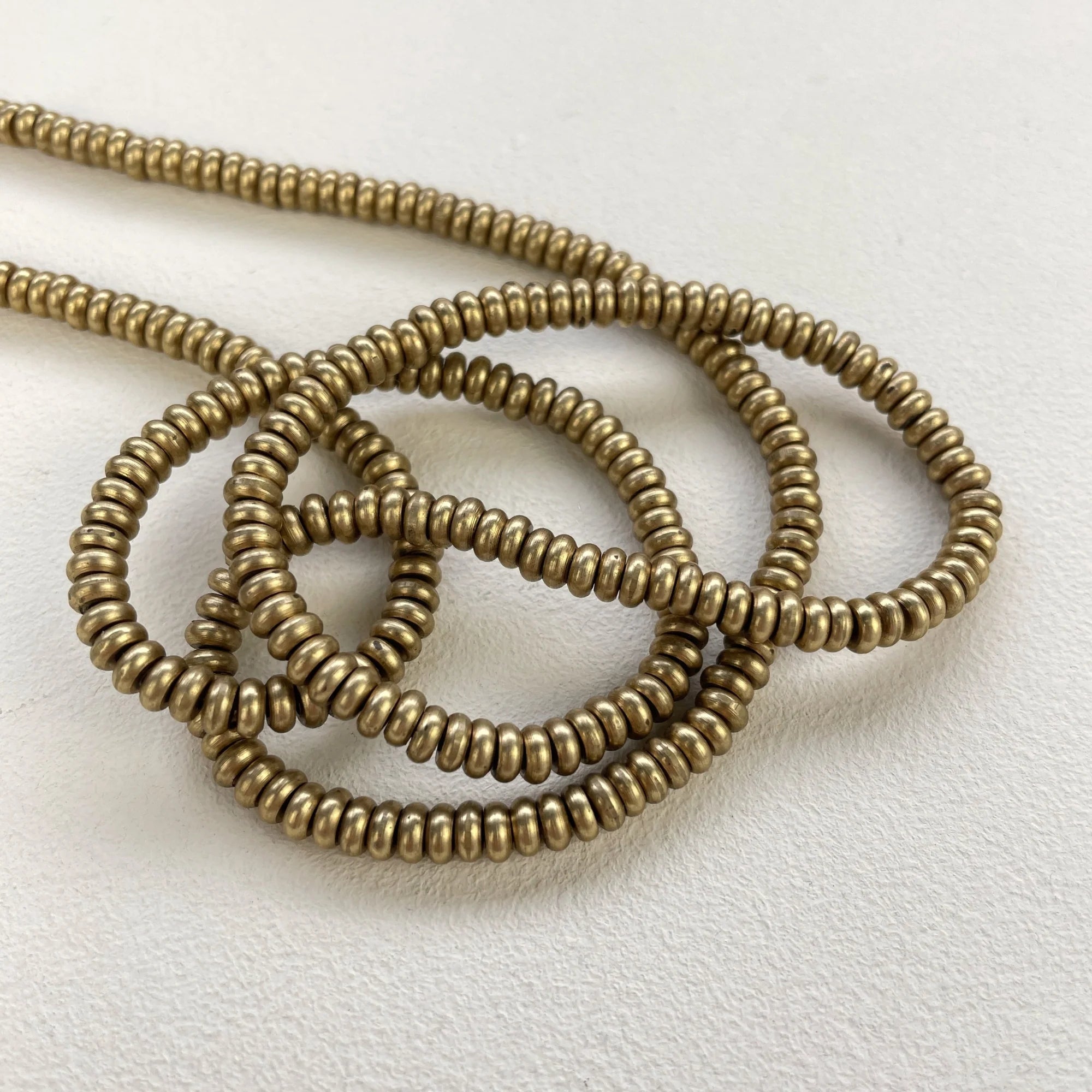 Bronze beaded necklace on a light gray background