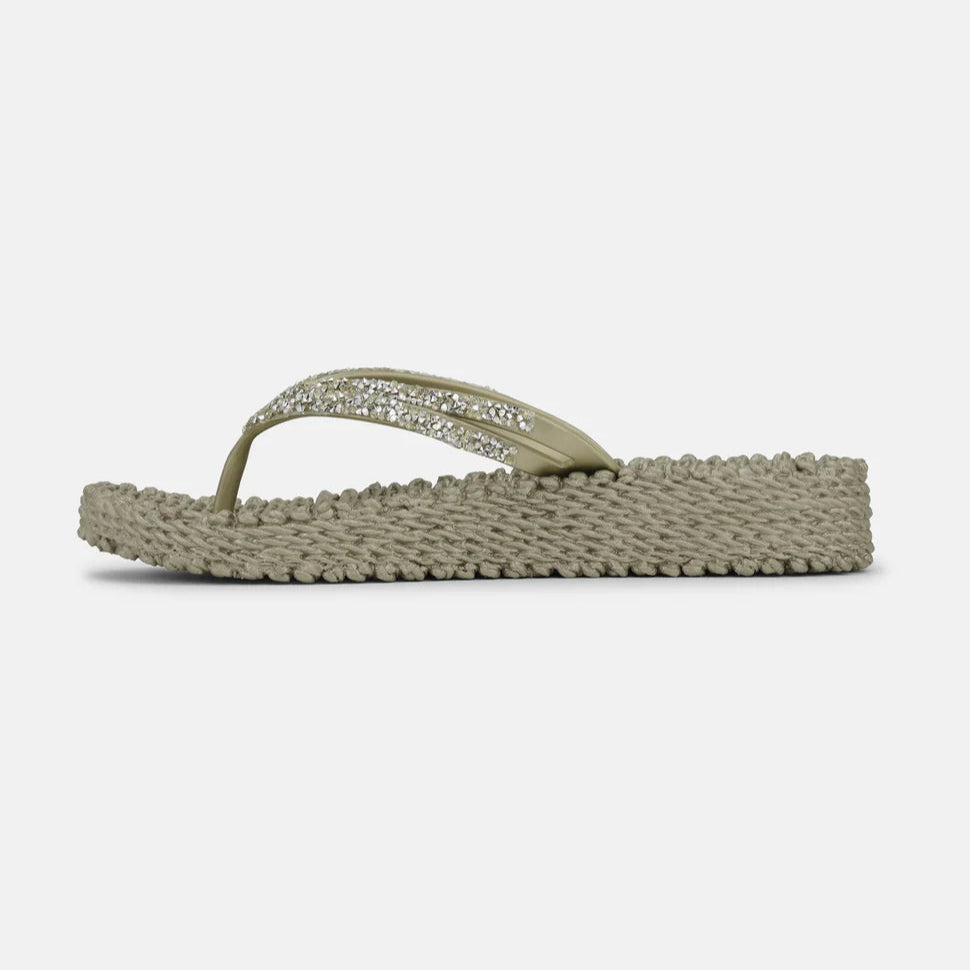 Beige sparkly thong sandals with textured sole. The straps feature a line of small, clear rhinestones.