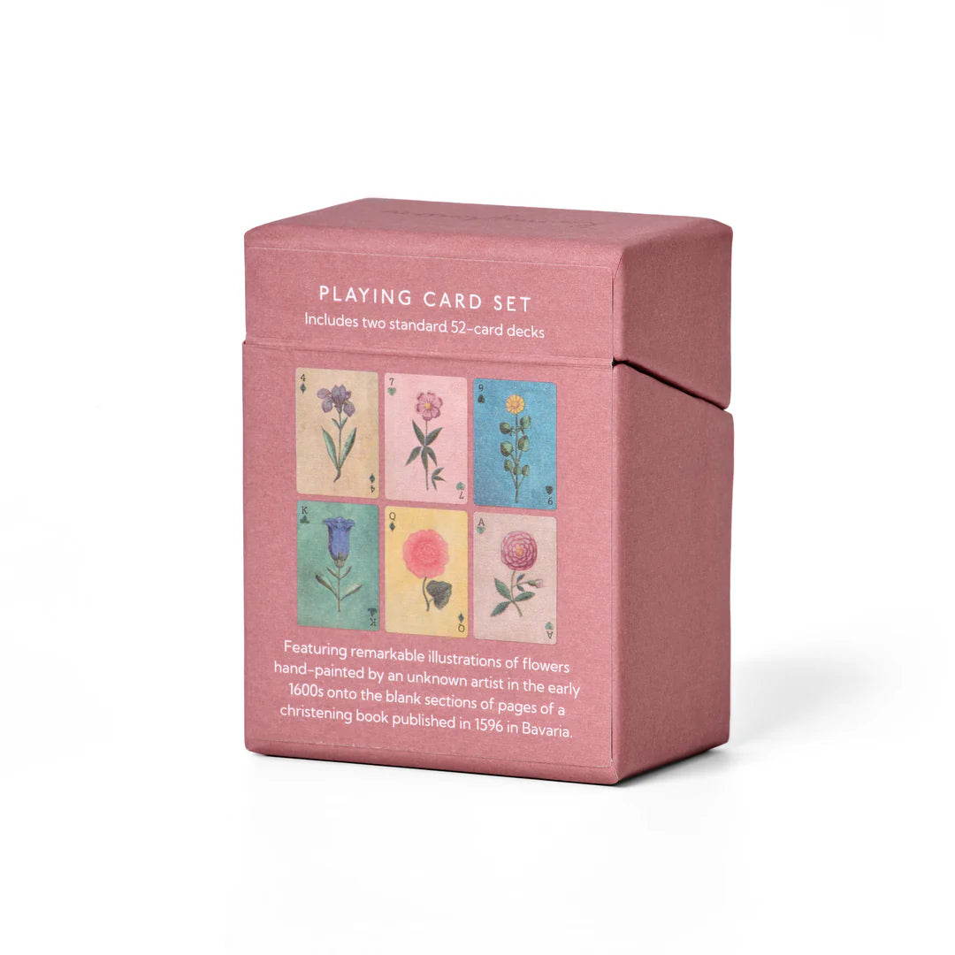 Pink playing card set packaging with floral illustrations on a white background