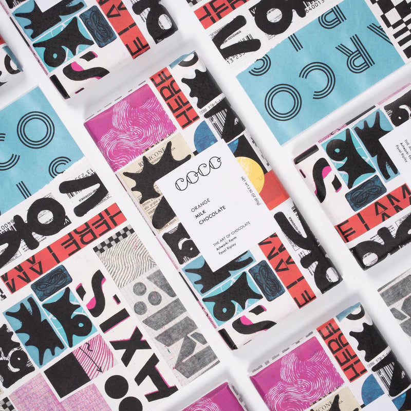 Orange milk chocolate bar with bold, abstract collage-style packaging in black, pink, and teal.
