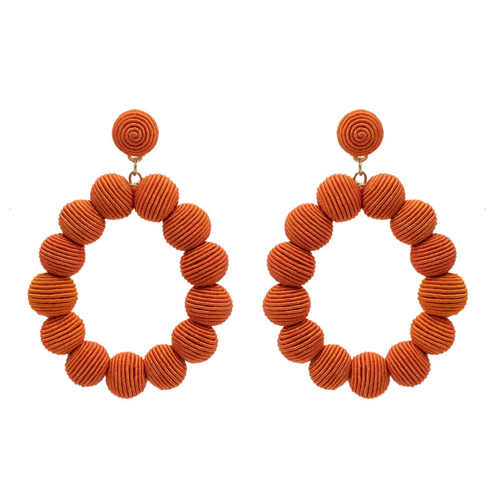 Pair of burnt orange hoop earrings.  Each hoop is composed of numerous small, textured spheres.