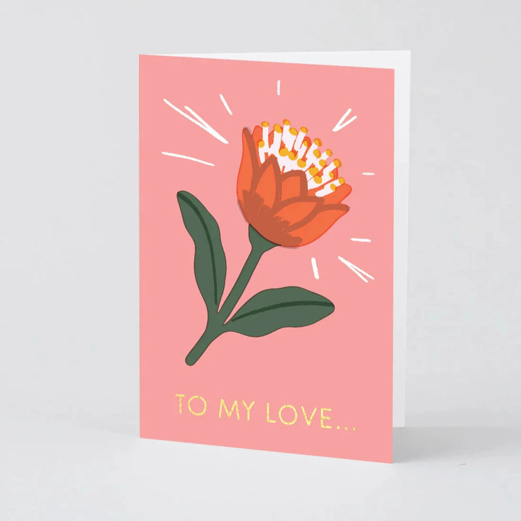 Pink greeting card featuring a stylized orange flower with gold text reading "To my love..."