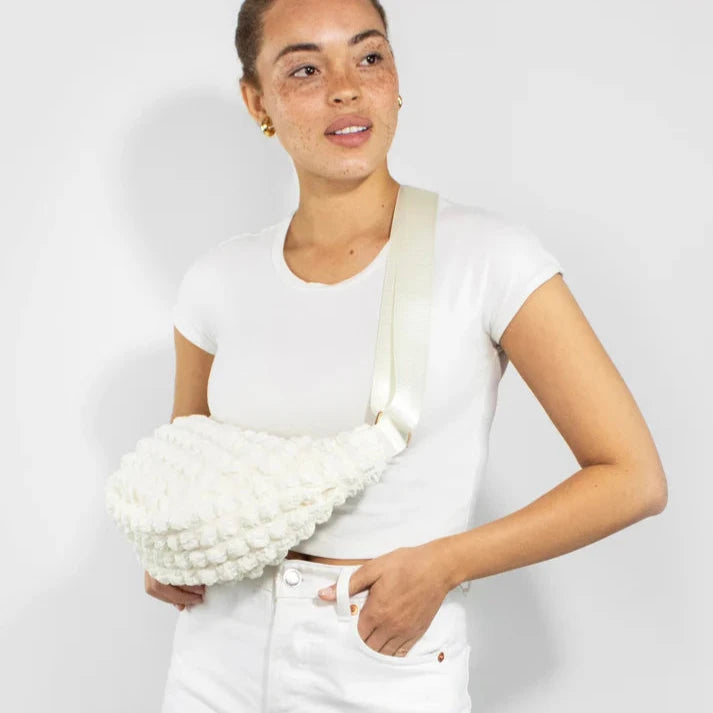 Off-white crocheted crossbody bag with a textured, puffy design and a cream-colored strap.
