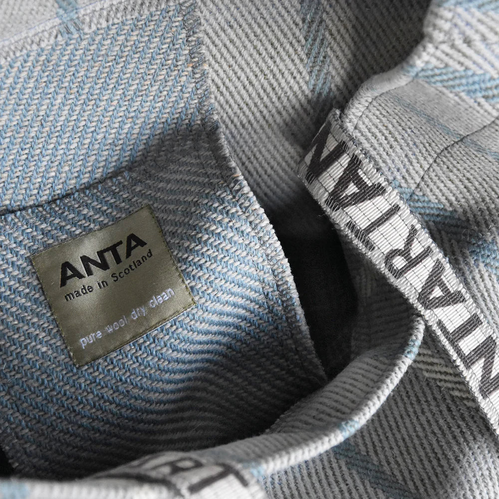 Close-up of a gray and blue herringbone pure wool shirt with "ANTA made in Scotland" label.
