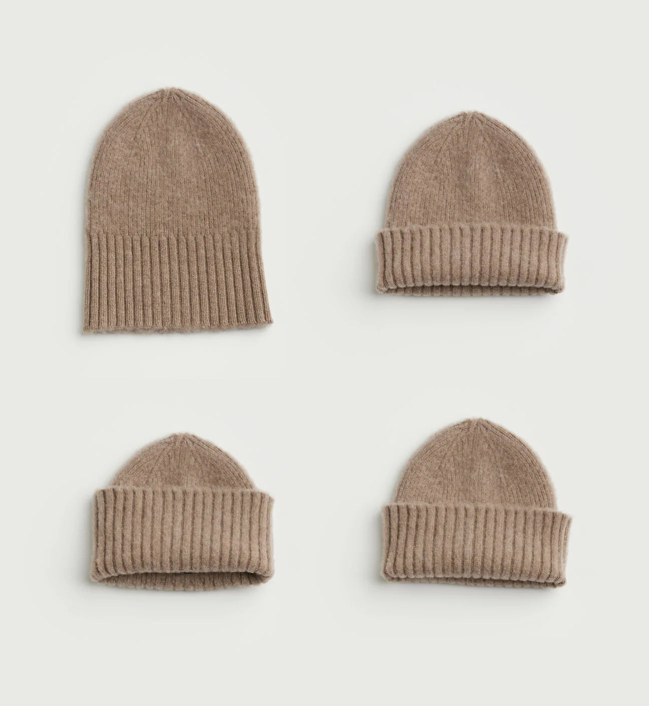 Four brown knit hats arranged on a light gray background