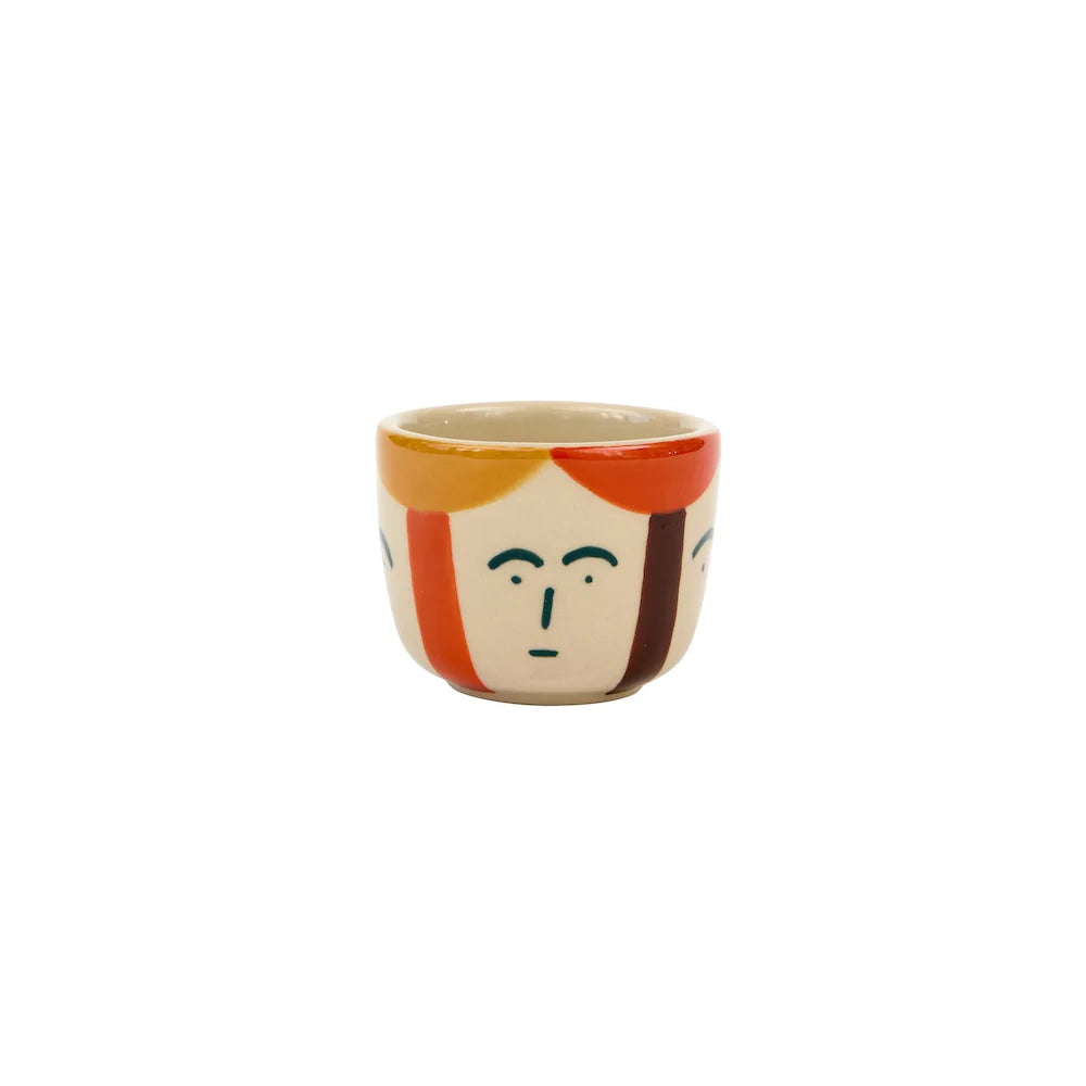 Ceramic mug with a face design on a white background