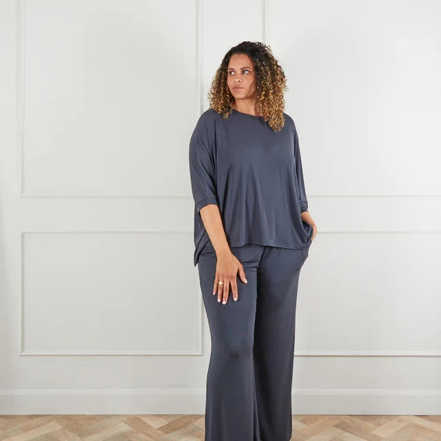 Model wearing a slate gray outfit by Chalk UK, featuring a loose top and wide-leg pants, against a neutral background.