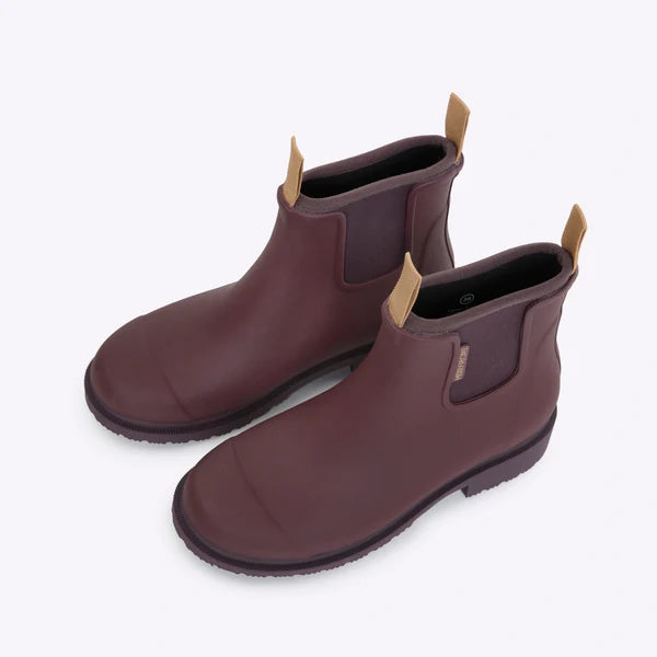 Pair of burgundy rubber Chelsea boots with tan pull tabs.