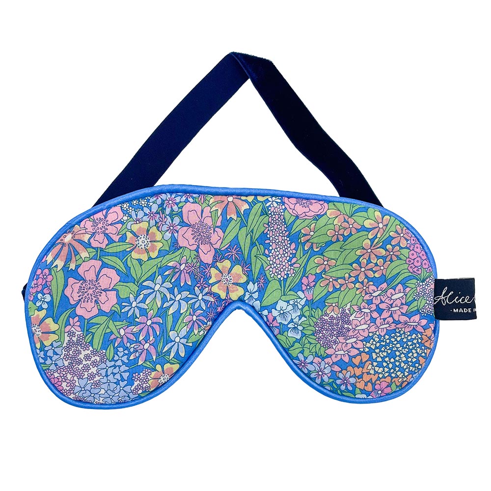 Blue sleep mask with a floral print. Features a dark navy velvet strap.
