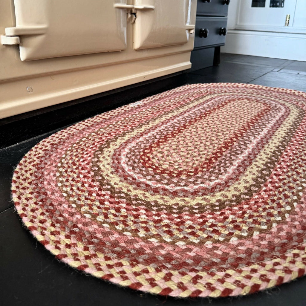 Close-up of a coral oval rug from The Braided Rug Company, showing its texture