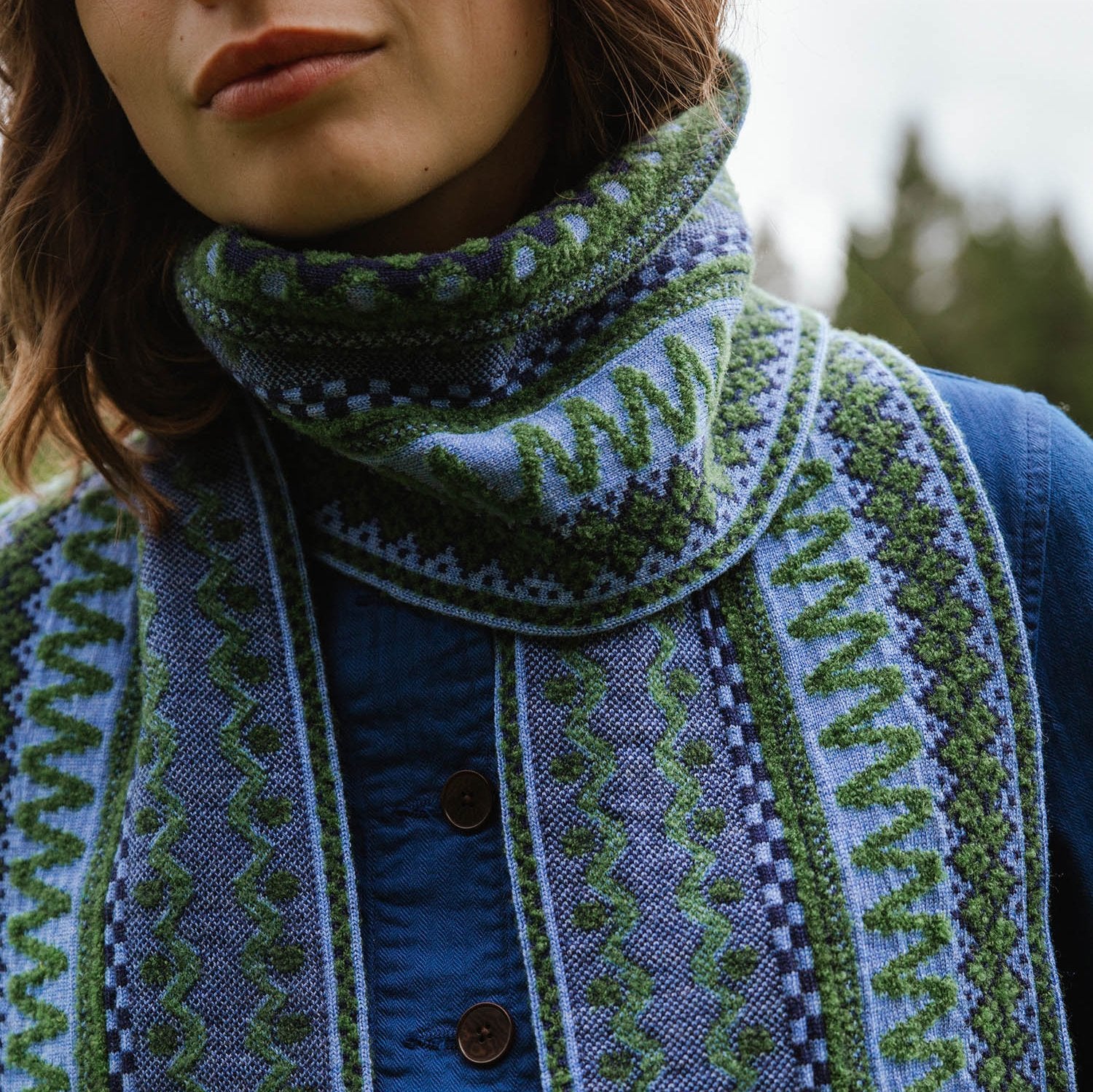 Blue and green patterned wool scarf with intricate textured design.