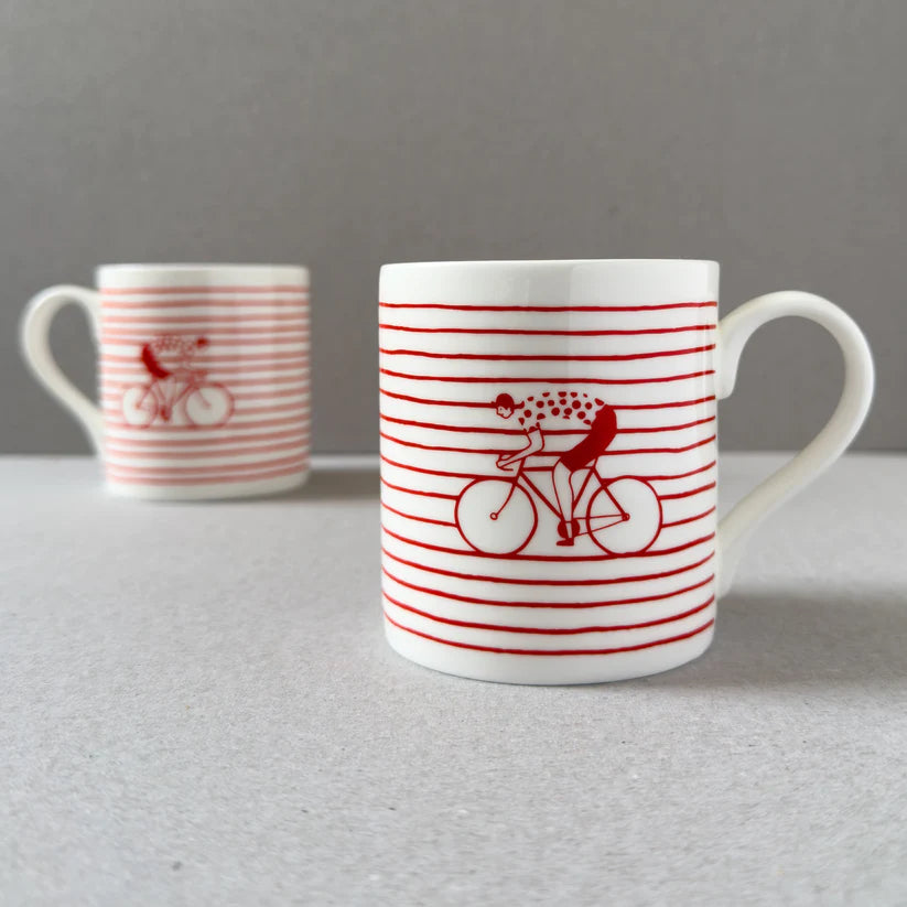 Red-striped mug featuring a cyclist on a bicycle.