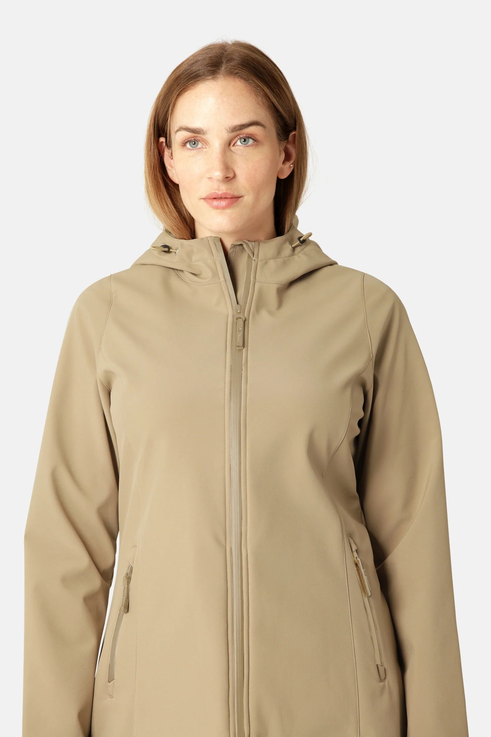 Beige softshell hooded jacket with zipper closure and zippered pockets; model wearing the jacket.
