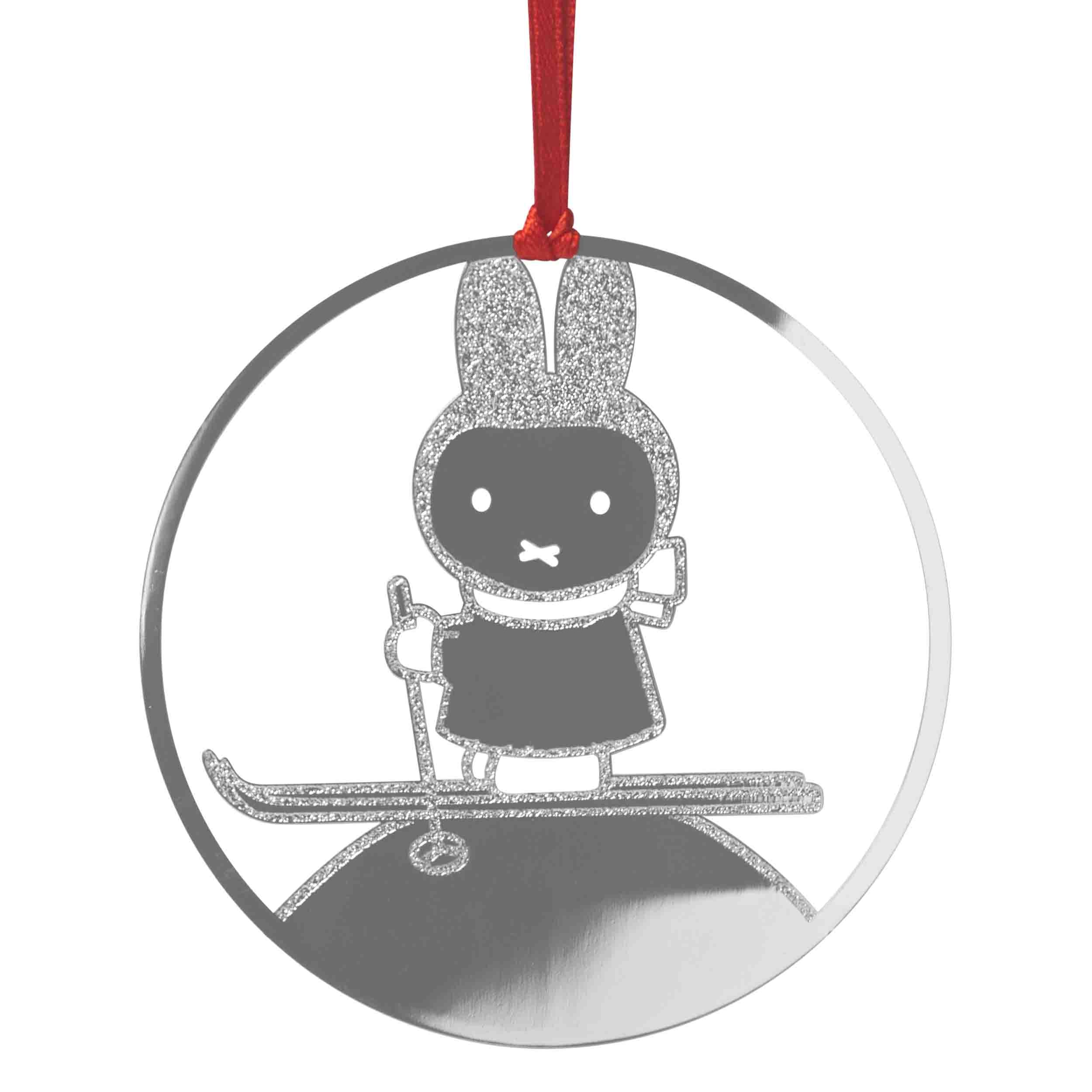 Silver glitter Miffy rabbit skiing ornament.  Round, hanging design with red ribbon.
