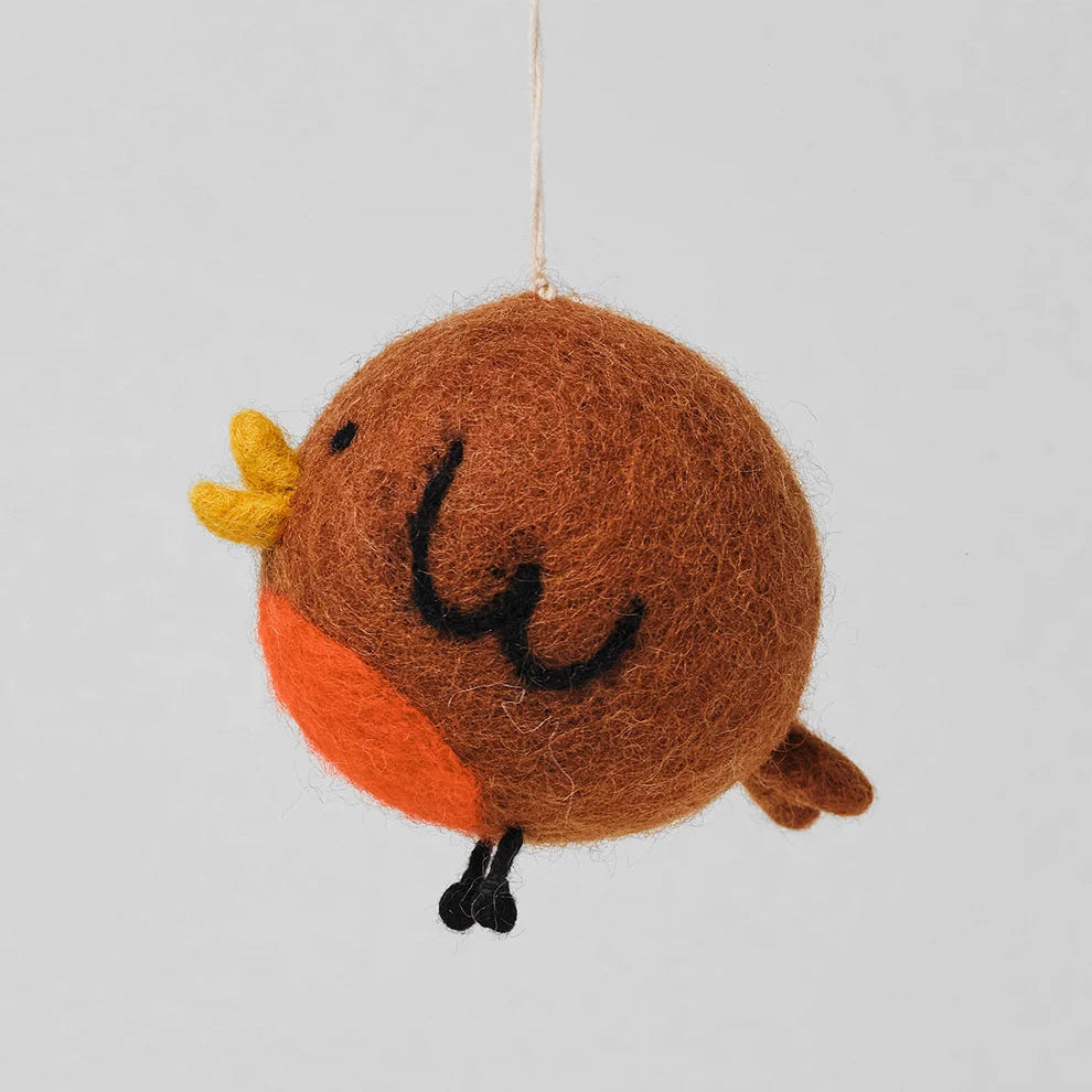 A handmade felted wool bird ornament in brown, orange, and yellow, hanging from a thin white string against a solid light gray background.