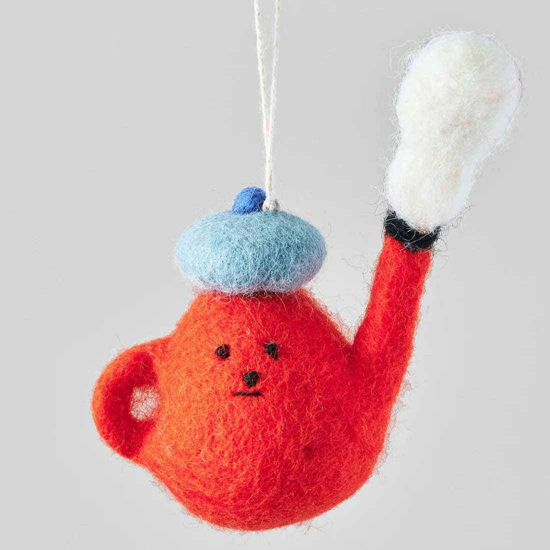 Needle-felted teapot ornament; orange body, light blue beret, white and black spout.